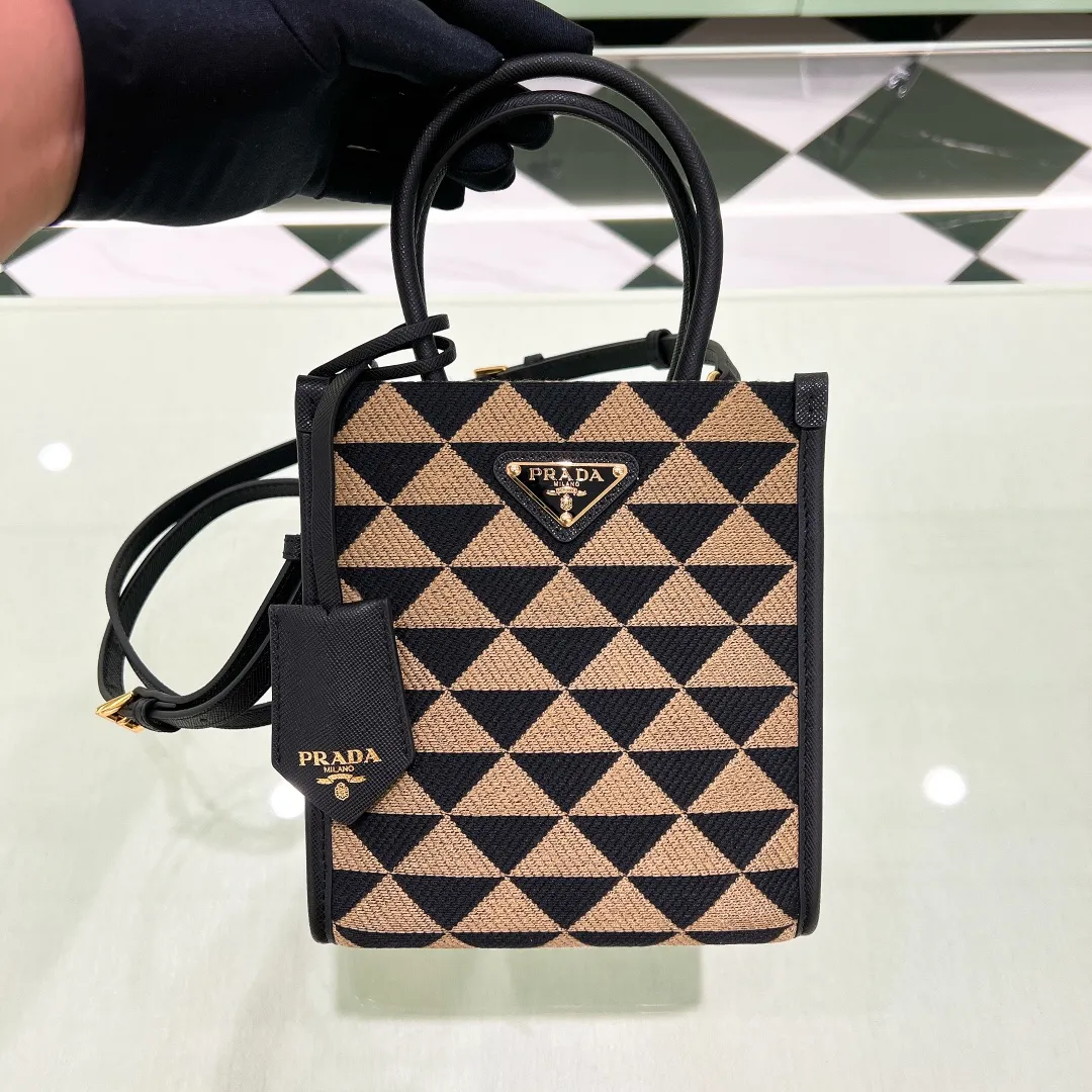 💰1320✨New product debut✨🌟New product, new series embroidered triangle plaid tote bag 1BA355 small size. The new fashion favorite tote bag that is popular all over the world. The bag is embroidered with triangular geometric patterns all over the body and imported cross-grain cowhide trimming. The overall bag is simple, elegant and luxurious in texture. The golden triangle logo on the front is added with Saffiano cowhide nameplate. The small bag has a large capacity. Full of points for matching. A must-have tote bag for little fairies, size 19*6*17cm