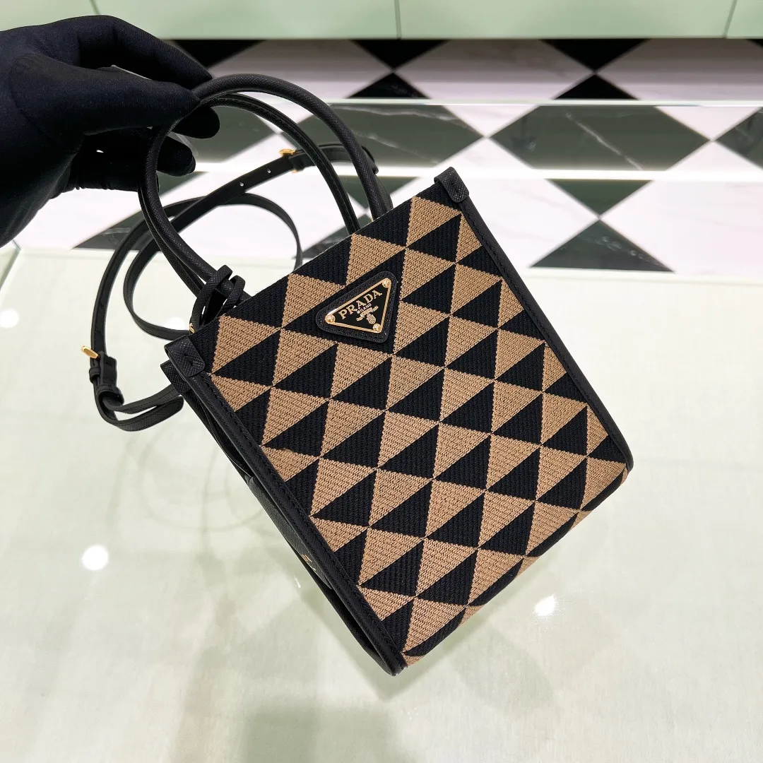 💰1320✨New product debut✨🌟New product, new series embroidered triangle plaid tote bag 1BA355 small size. The new fashion favorite tote bag that is popular all over the world. The bag is embroidered with triangular geometric patterns all over the body and imported cross-grain cowhide trimming. The overall bag is simple, elegant and luxurious in texture. The golden triangle logo on the front is added with Saffiano cowhide nameplate. The small bag has a large capacity. Full of points for matching. A must-have tote bag for little fairies, size 19*6*17cm