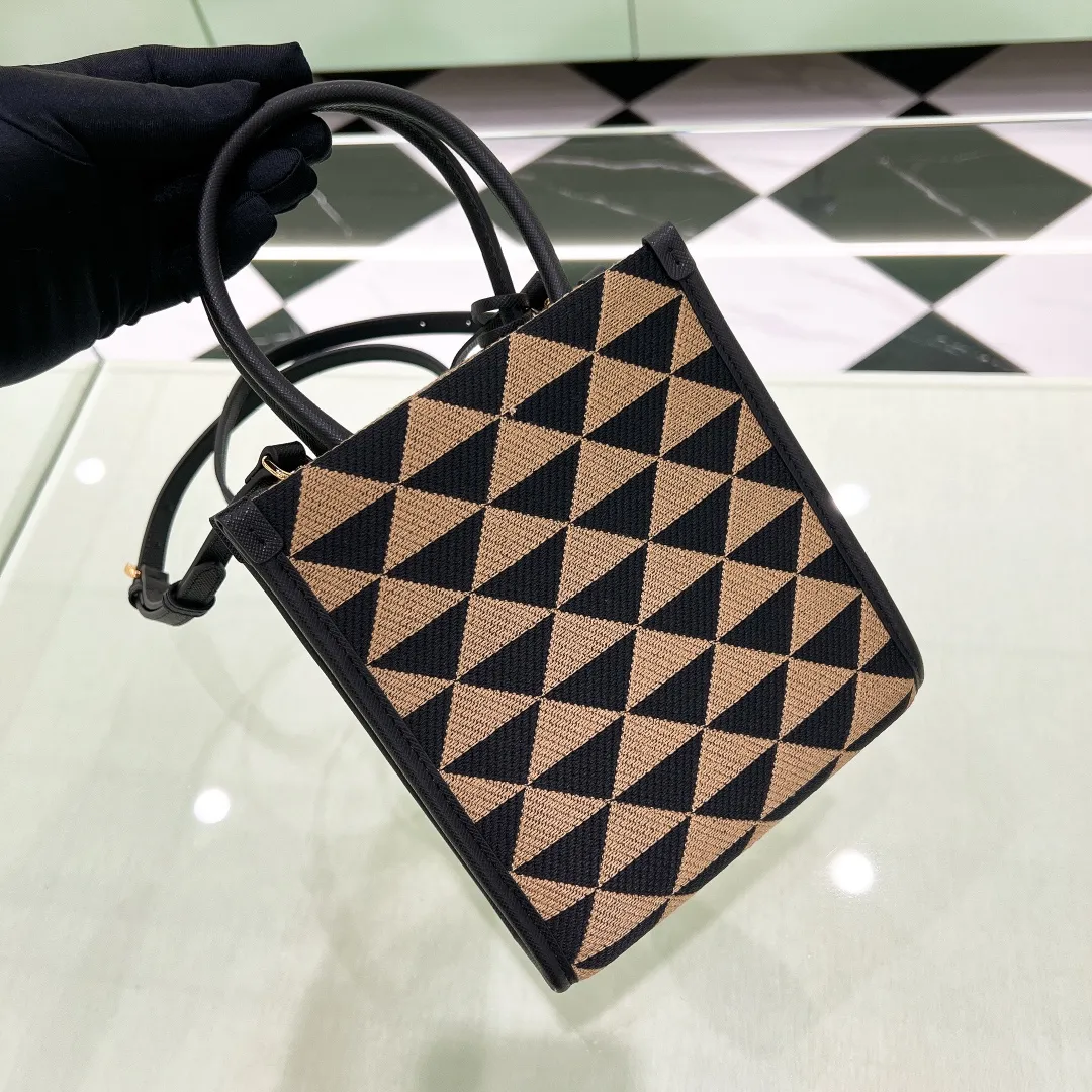 💰1320✨New product debut✨🌟New product, new series embroidered triangle plaid tote bag 1BA355 small size. The new fashion favorite tote bag that is popular all over the world. The bag is embroidered with triangular geometric patterns all over the body and imported cross-grain cowhide trimming. The overall bag is simple, elegant and luxurious in texture. The golden triangle logo on the front is added with Saffiano cowhide nameplate. The small bag has a large capacity. Full of points for matching. A must-have tote bag for little fairies, size 19*6*17cm
