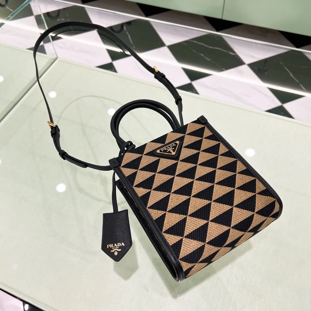 💰1320✨New product debut✨🌟New product, new series embroidered triangle plaid tote bag 1BA355 small size. The new fashion favorite tote bag that is popular all over the world. The bag is embroidered with triangular geometric patterns all over the body and imported cross-grain cowhide trimming. The overall bag is simple, elegant and luxurious in texture. The golden triangle logo on the front is added with Saffiano cowhide nameplate. The small bag has a large capacity. Full of points for matching. A must-have tote bag for little fairies, size 19*6*17cm