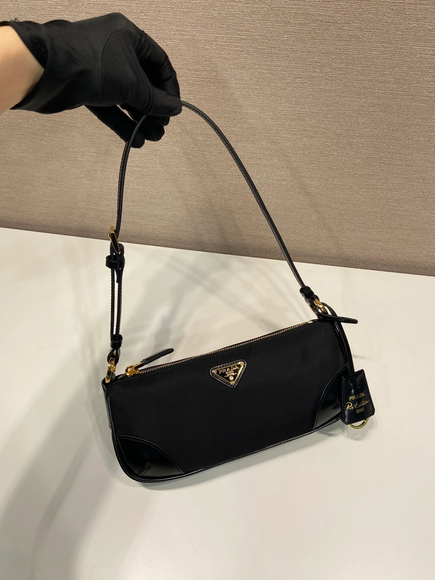 💰860🎉New armpit bag🎉1BC201/2002 model🎉🎉 This elegant and simple Re-Edition 2002 shoulder bag is made of innovative Re-Nylon regenerated nylon fabric and decorated with glossy leather details. Incorporating P-style and versatile design elements, it is equipped with adjustable shoulder straps, metal hardware and a detachable key ring. The enameled triangular metal logo highlights the brand's classic character. Lightweight and practical, get it now🎉 Length 23.5x Height 10x Bottom 5cm🎉🎉🎉👏👏👏