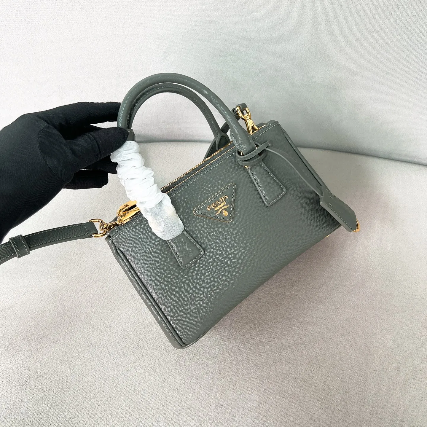 💰1700✨New product launch✨P classic Galleria Saffiano leather handbag - "Killer Bag" 2025 new product Mini No. 1BA916 People who understand fashion love killer bags. The bag should look like a killer bag. Carefully crafted with Saffiano cross pattern imported from Italy. Minimalist and capable bag shape with triangular metal lettering logo. Double zipper design, middle main bag with extra large capacity. Double handles and detachable shoulder straps make it It can be carried by hand or carried cross-body. It can be opened and closed with side snap buttons. The bag body changes to add elegance and elegance. It is small and exquisite, adding a playful and fashionable feel. Size 21*12.5*8.5 Gray