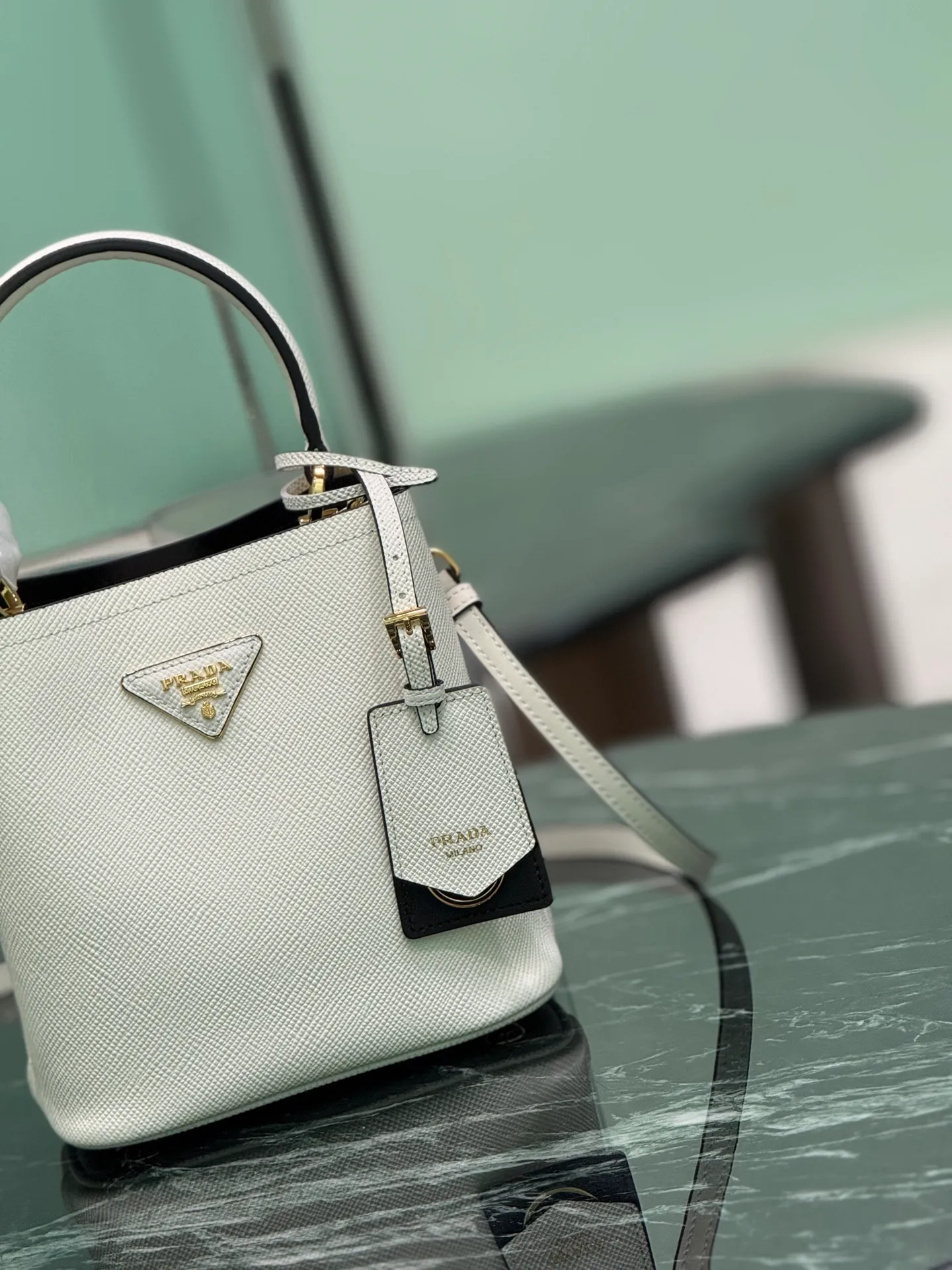 💰1700🌟 Classic bucket bag (new tag) Saffiano leather material Leather handles Detachable and adjustable leather shoulder strap Detachable leather name tag with metal logo Leather-covered central opening with magnetic buckle Saffiano leather triangle logo Contrast color nappa leather lining Size: 18×17×10.5cm Style number: 1BA217 (mini size)