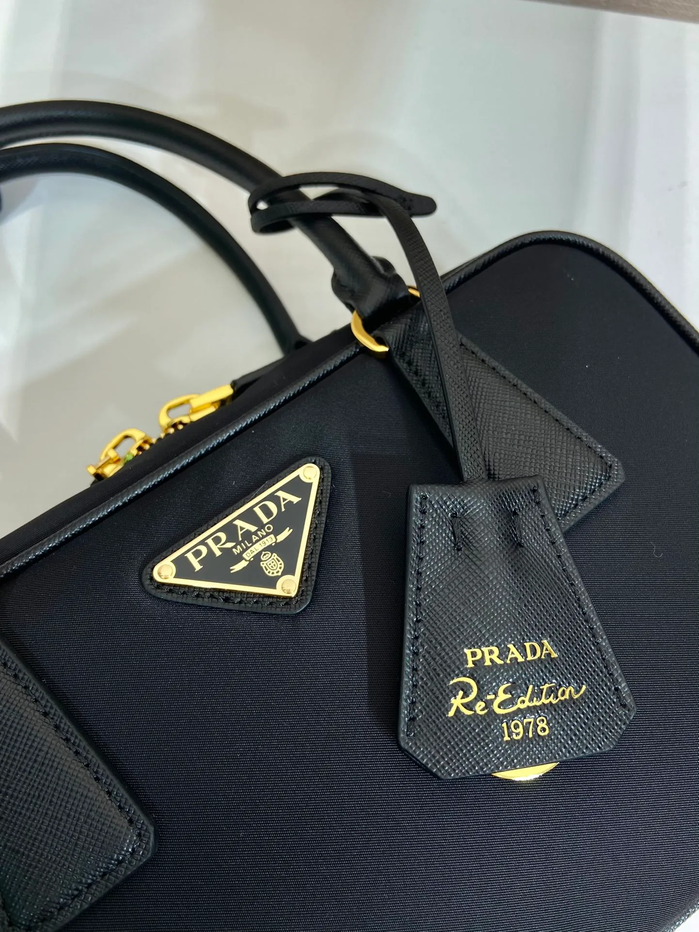 💰1360🎉New second-hand bag🎉1BB121 small🎉🎉 This double handle handbag is made of regenerated nylon, incorporating unique style elements and exquisite Saffiano leather details, completely subverting people's traditional perception of luxury goods. Practical design embellishments and exquisite details add a unique charm. Large capacity, practical and elegant👏Another popular style that will never go out of style🎉🎉 Length 25 height 14.5x bottom 7.5cm👏👏👏🎉🎉🎉