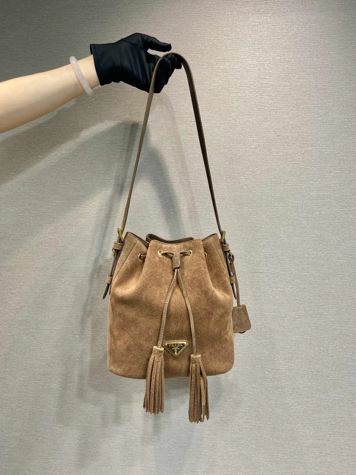 💰1400🎉New bucket bag🎉1BE079 suede leather🎉🎉 This flexible and easy-to-wear bucket bag has a minimalist design and is made of soft suede leather. The shoulder straps are adjustable, and the front panel is designed with 2 tassels. It has a large capacity space, and the upper body effect is fashionable. It is a must-have in winter and is worth owning👏👏👏 Length 25x Height 22x Bottom 13cm🎉🎉🎉👏👏👏