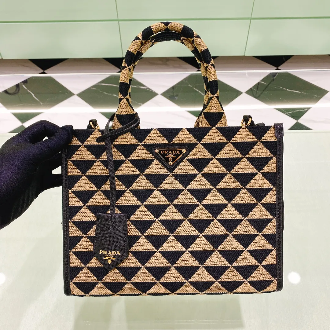 💰1560✨New product debut✨🌟New product, new series embroidered triangle plaid tote bag 1BA354 medium size. The new fashion favorite tote bag that is popular all over the world. The bag is embroidered with triangular geometric patterns all over the body and imported cross-grain cowhide trim. The overall bag is simple, elegant and luxurious in texture. The golden triangle logo on the front is added with Saffiano cowhide name plate. It is equipped with a detachable full leather shoulder strap. It has a large capacity and is full of matching points. A must-have tote bag for little fairies, size 22*9*28cm
