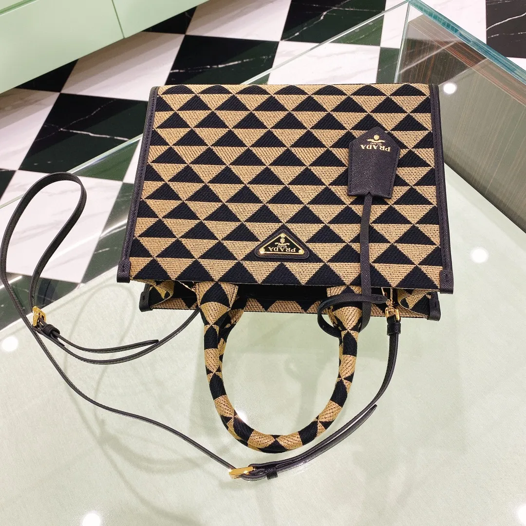 💰1560✨New product debut✨🌟New product, new series embroidered triangle plaid tote bag 1BA354 medium size. The new fashion favorite tote bag that is popular all over the world. The bag is embroidered with triangular geometric patterns all over the body and imported cross-grain cowhide trim. The overall bag is simple, elegant and luxurious in texture. The golden triangle logo on the front is added with Saffiano cowhide name plate. It is equipped with a detachable full leather shoulder strap. It has a large capacity and is full of matching points. A must-have tote bag for little fairies, size 22*9*28cm