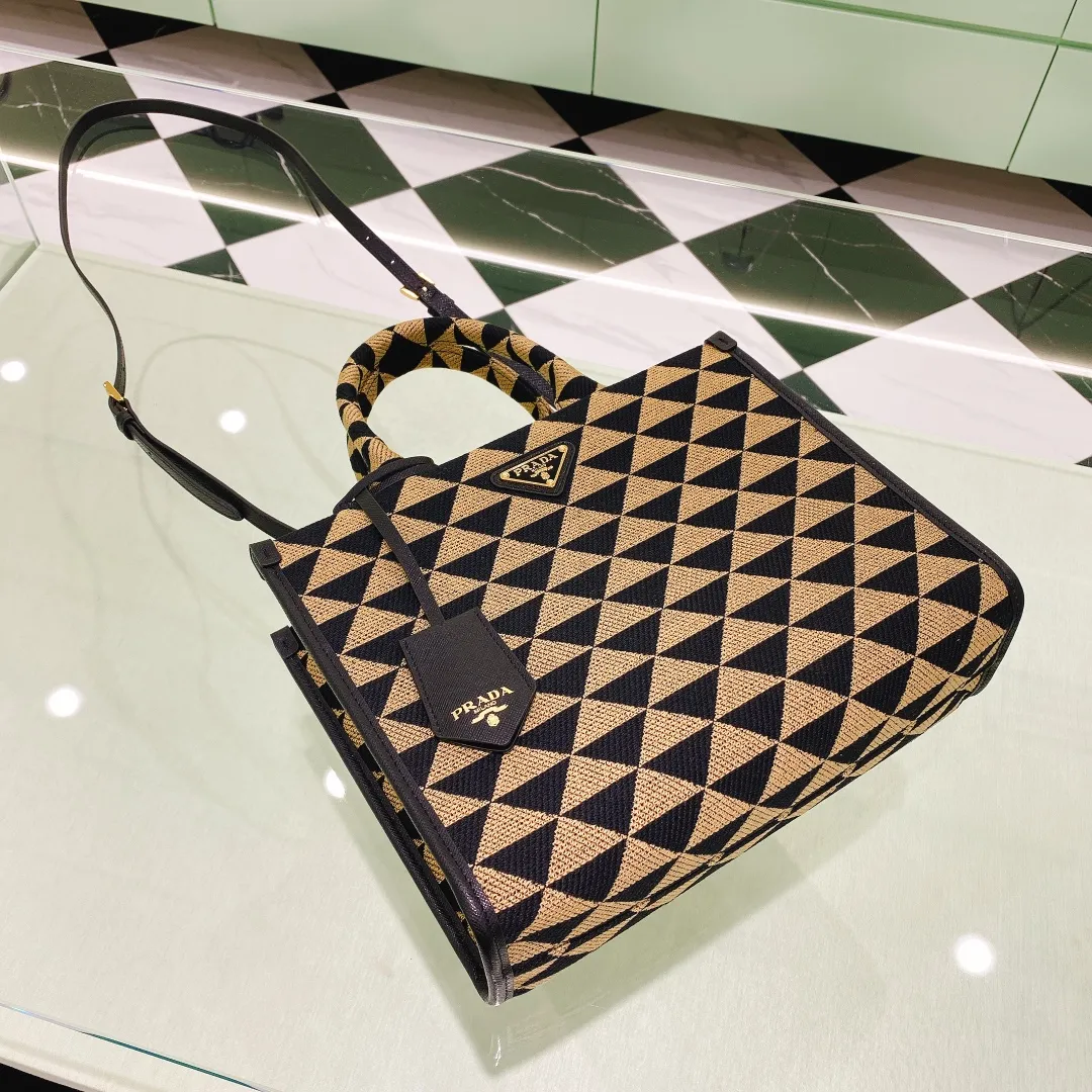 💰1560✨New product debut✨🌟New product, new series embroidered triangle plaid tote bag 1BA354 medium size. The new fashion favorite tote bag that is popular all over the world. The bag is embroidered with triangular geometric patterns all over the body and imported cross-grain cowhide trim. The overall bag is simple, elegant and luxurious in texture. The golden triangle logo on the front is added with Saffiano cowhide name plate. It is equipped with a detachable full leather shoulder strap. It has a large capacity and is full of matching points. A must-have tote bag for little fairies, size 22*9*28cm