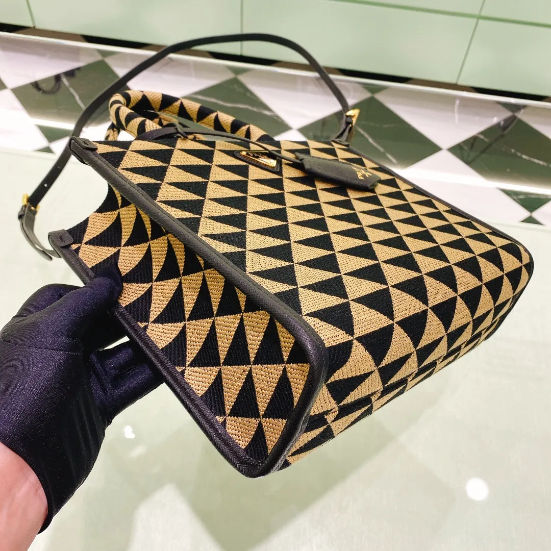 💰1560✨New product debut✨🌟New product, new series embroidered triangle plaid tote bag 1BA354 medium size. The new fashion favorite tote bag that is popular all over the world. The bag is embroidered with triangular geometric patterns all over the body and imported cross-grain cowhide trim. The overall bag is simple, elegant and luxurious in texture. The golden triangle logo on the front is added with Saffiano cowhide name plate. It is equipped with a detachable full leather shoulder strap. It has a large capacity and is full of matching points. A must-have tote bag for little fairies, size 22*9*28cm