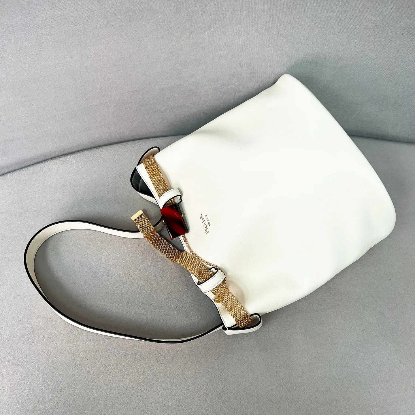 💰1700✨New product launch✨2025 spring and summer new product Buckle bucket bag 1BE085 inherits the classic bucket bag shape. The newly designed leather belt has a unique style that makes the bag infinitely dynamic. It is made of chic and noble calfskin. The bag is decorated with metallic mesh design. It is equipped with tortoise shell panel buckle. Elegant and simple bag body design is decorated with unique hardware decoration, showing a refined and elegant aesthetic style. Equipped with an adjustable hand strap, perfect details comparable to brick cabinets, super awesome 5🌟 size: 29*26.5*18cm white