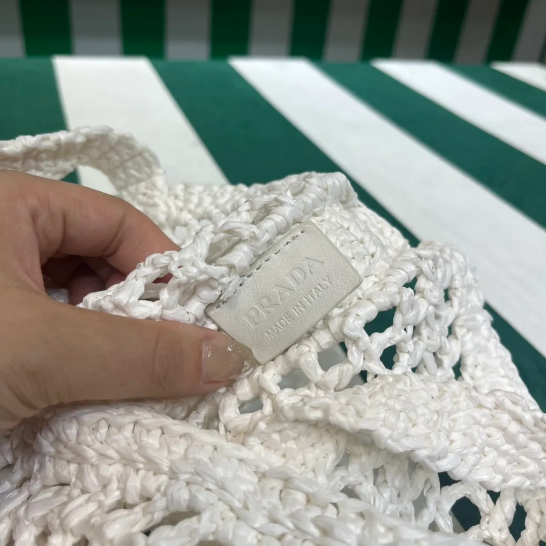 💰1160 Raffia Upgraded Version/White🦴 𝗣𝗿'𝗮𝗱𝗮Raffia Fiber Tote Bag Made of high-quality imported raffia🌿 Purely handmade! Every craftsman makes it with care and crochets it stitch by stitch! How can summer outings, picnics, and photo shoots be complete without a beautiful, lightweight and chic straw bag? 393 Size: 36×4×38cm