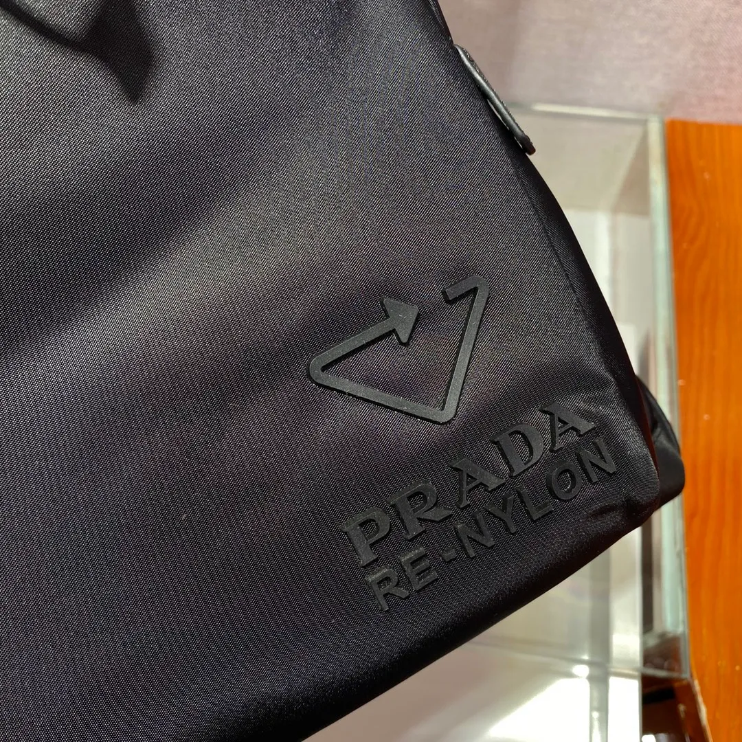 💰1320🎉Environmental protection series🎉2VZ135🎉🎉This backpack is made of innovative regenerated nylon fabric and has a classic design. Featuring a flap with strap and buckle and four exterior zipped pockets. The padded back reveals practical details, and the signature enameled triangle metal logo reinforces the brand's identity. Simple and elegant, men, hurry up and get it, it is another backpack that will never go out of style👏👏 Length 27x Height 45x Bottom 17cm