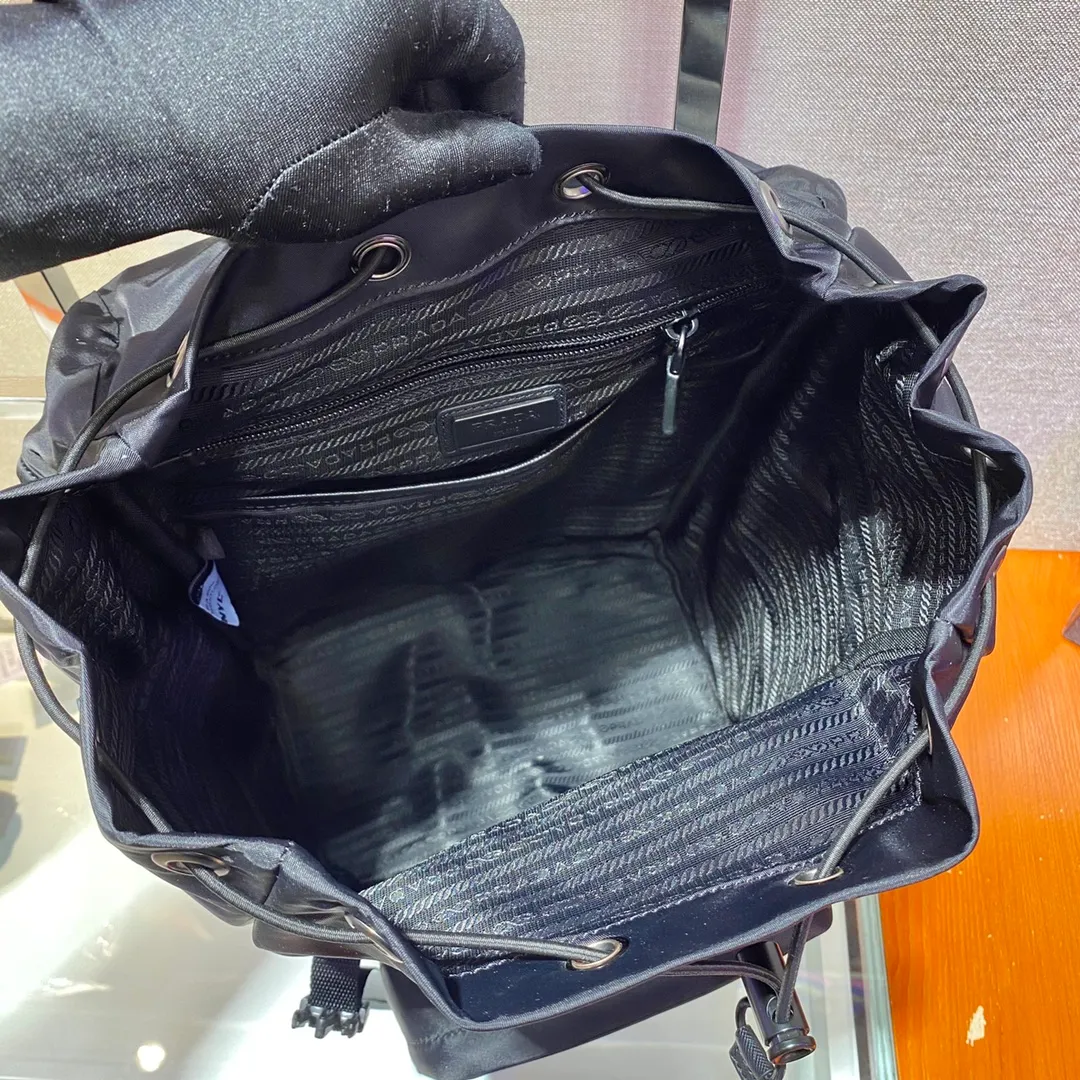 💰1320🎉Environmental protection series🎉2VZ135🎉🎉This backpack is made of innovative regenerated nylon fabric and has a classic design. Featuring a flap with strap and buckle and four exterior zipped pockets. The padded back reveals practical details, and the signature enameled triangle metal logo reinforces the brand's identity. Simple and elegant, men, hurry up and get it, it is another backpack that will never go out of style👏👏 Length 27x Height 45x Bottom 17cm