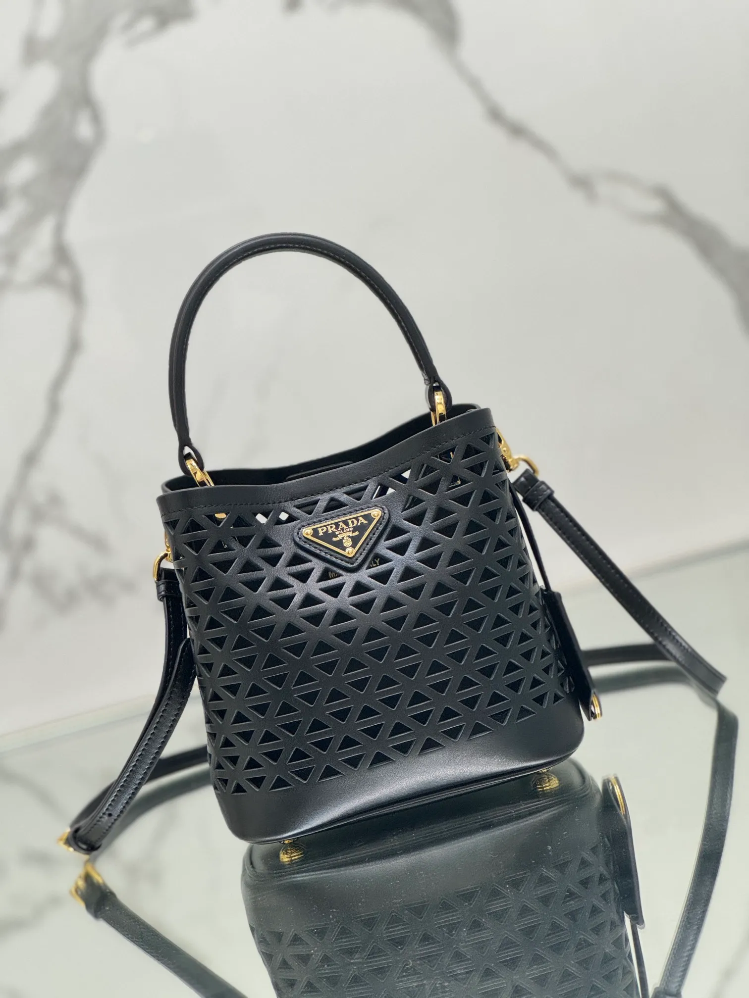 💰1640🌟Hollowout🐮Leather bucket bag The popular "elf" Saffiano perforated calfskin gives this P bucket bag a unique charm. The shape is not too soft and lacks spirit, nor is it too dull and lacks texture. The cute mini size adds a sense of fashion. It can be carried in hand, shoulder or crossbody. It is a handbag that perfectly integrates classic heritage and the trend of the times. Size: 18×17×10.5 cm Style number: 1BA217