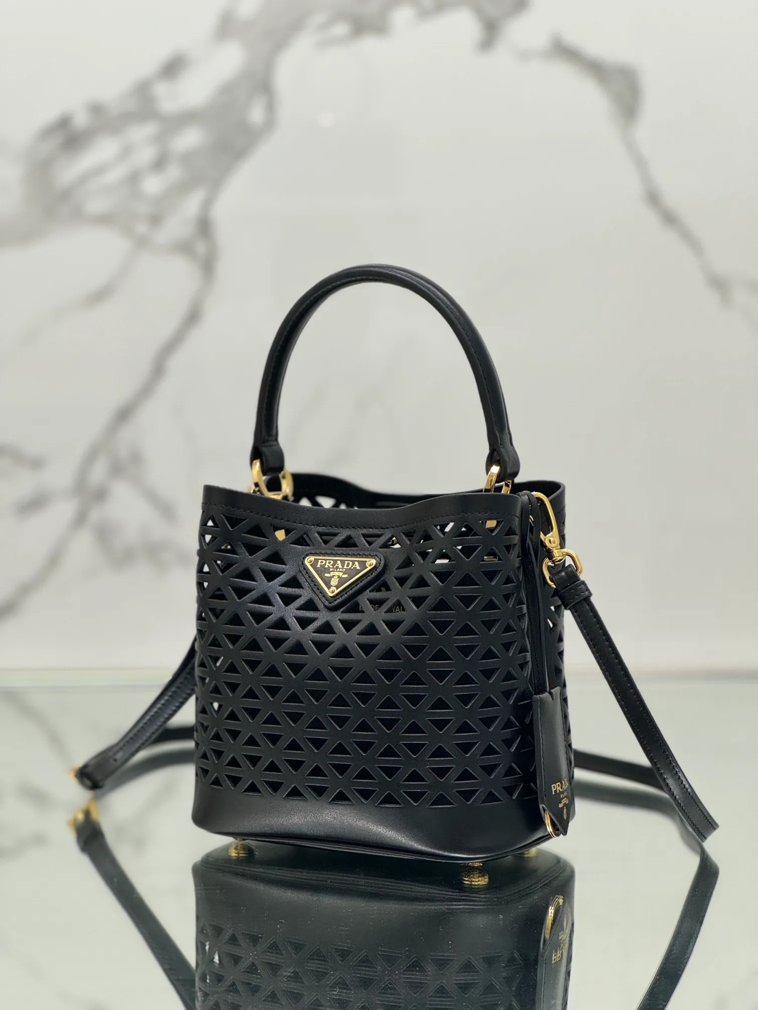 💰1640🌟Hollowout🐮Leather bucket bag The popular "elf" Saffiano perforated calfskin gives this P bucket bag a unique charm. The shape is not too soft and lacks spirit, nor is it too dull and lacks texture. The cute mini size adds a sense of fashion. It can be carried in hand, shoulder or crossbody. It is a handbag that perfectly integrates classic heritage and the trend of the times. Size: 18×17×10.5 cm Style number: 1BA217