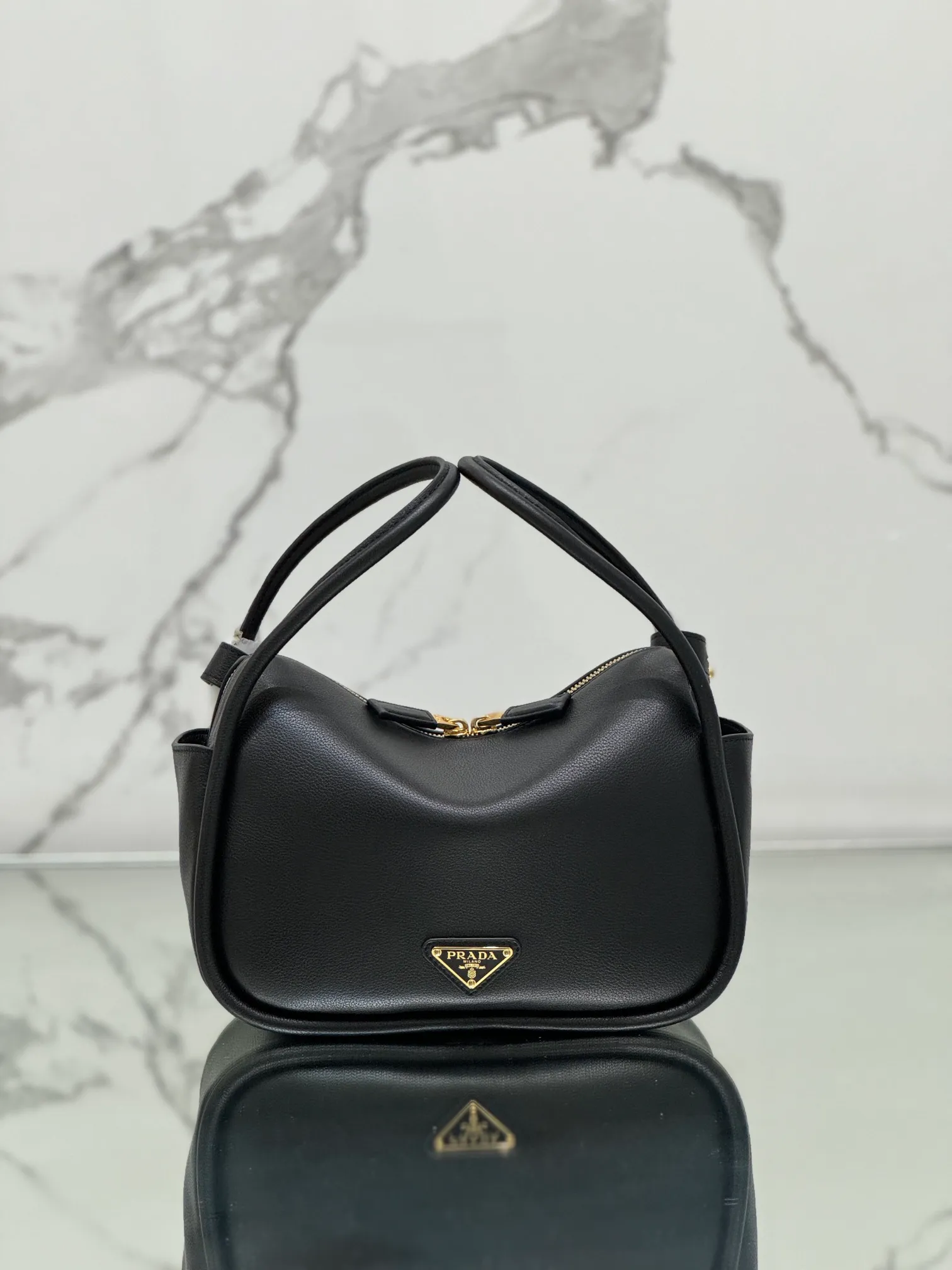 💰1500⭐ New bowling bag This Lindy handbag/shoulder bag is made of Italian Soft Grain imported calfskin, with top-grade hardware. The modern design highlights the casual attitude, and the exquisite details and metal hardware accessories add to the smartness. Sophisticated and versatile, the style is crafted from soft grained cowhide with smooth, minimal lines. Showcasing exceptional craftsmanship, this accessory is embellished with an enameled triangular metal logo. It can be carried by hand, shoulder, or cross-body. It has large capacity, is simple and practical, and has a great upper body😘 ●Double handles, 13 cm drop length ●Detachable shoulder strap, 75 cm long ·Open side pockets·Metal hardware accessories ·Enameled triangular metal logo on the front ·Zipper closure ·Lined and patch pockets Style number: 1ba451 Size: 25*18*10.5cm