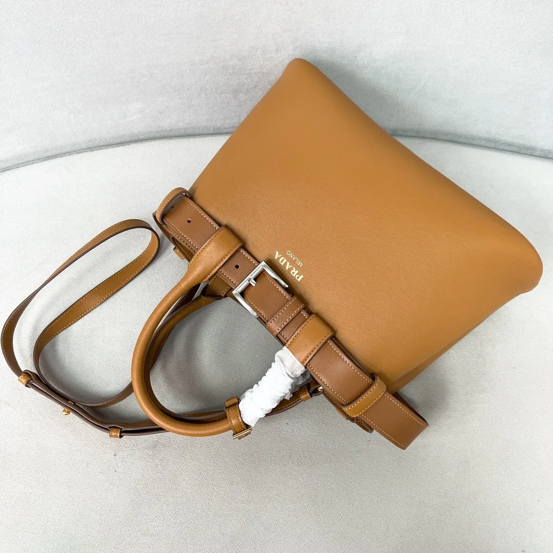 💰2040✨New product launch✨2024 early spring new medium wide drawstring leather handbag 1Ba434 Newly designed leather belt with unique style makes the bag infinitely dynamic. Made of chic and noble lambskin. Elegant and simple body design. Classic gold logo logo on the front. Equipped with adjustable shoulder straps, can be carried or worn cross-body. It has three compartments to meet exquisite storage needs. The perfect details are comparable to those of a brick cabinet. Super 5🌟 size: 32*23*11cm caramel color