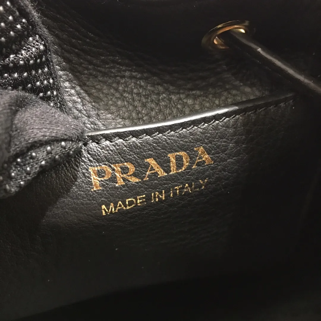 💰1660, P family has another popular bucket bag👏🏻👏🏻1BE018, the latest/most popular bucket bag🤙🤙Made of imported calfskin deerskin grain material, leather handle/2 replacement shoulder straps👏🏻👏🏻Detachable and adjustable colorful fabric shoulder straps, equipped with leather shoulder pads, metal lettering logo The top is decorated with a leather drawstring and is lined with a logo. There is a leather pocket inside, a large capacity and beautiful style🙋🏻🙋🏻, length 21x height 25x bottom 15cm.🤙