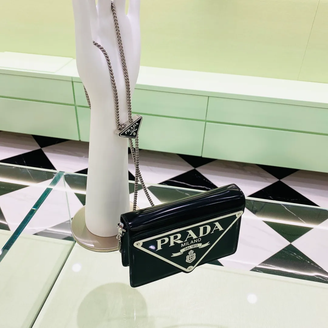 💰1320✨New product launch✨🌟New inverted triangle decorated glossy cowhide flip shoulder bag 1BH189 Novel and interesting inverted triangle metal chain with fashionable glossy cowhide Simple and elegant outline design and flip opening and closing, giving it a simple and fashionable style. It is simply great👏... The new favorite of fashion trendsetters The perfect details are comparable to those of brick cabinets Super 5🌟 Size:17*9.5*3.5cm black