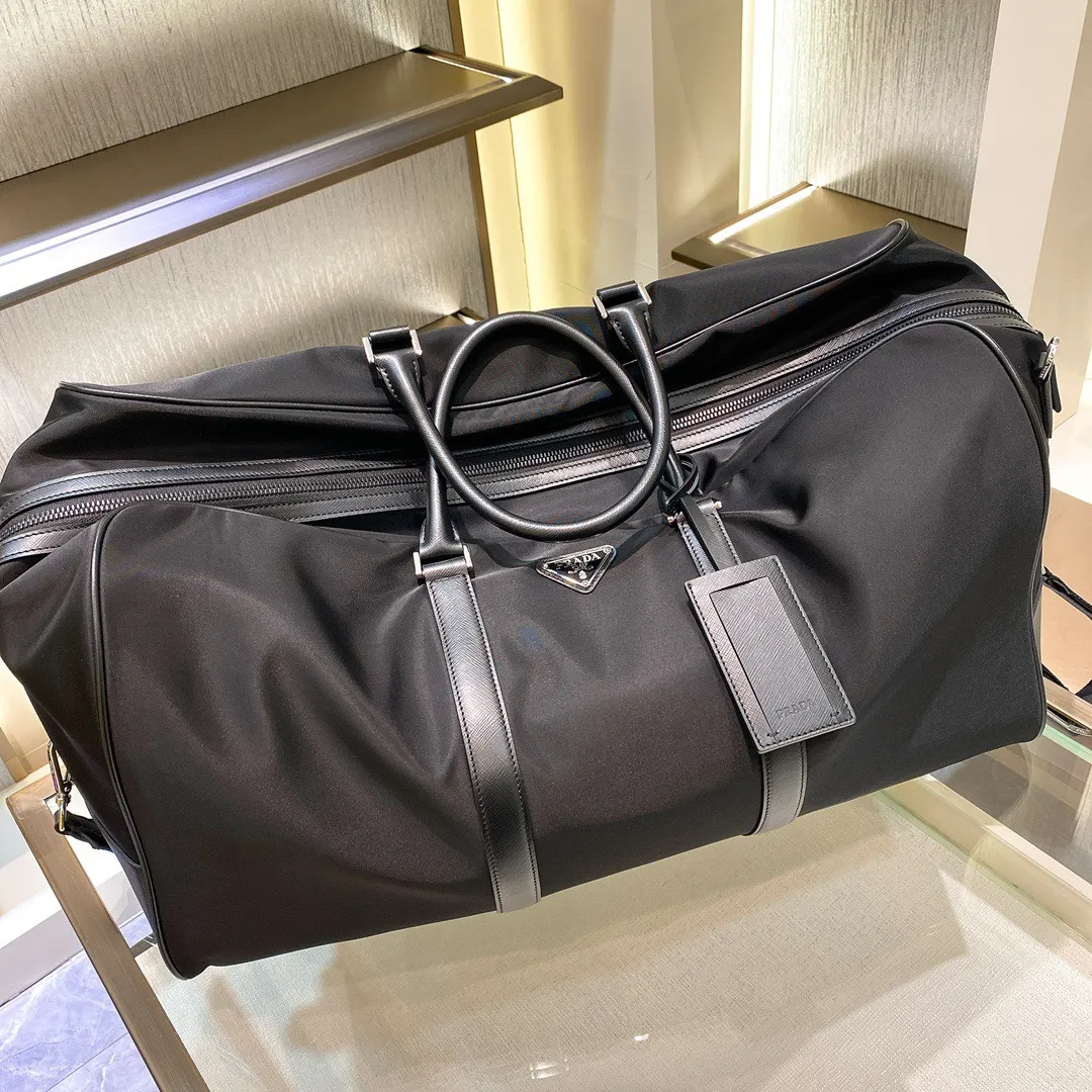 💰1580✨New product launch✨The latest nylon travel bag 2VC013 Imported parachute fabric + Saffiano cowhide Triangular enamel logo on the front Cross-grain cowhide handle Nylon is more lightweight Has a shoulder strap that can be detached at will A must-have for extra-large capacity travel Very convenient to carry on the plane✈ Size: 55*33*27cm Black