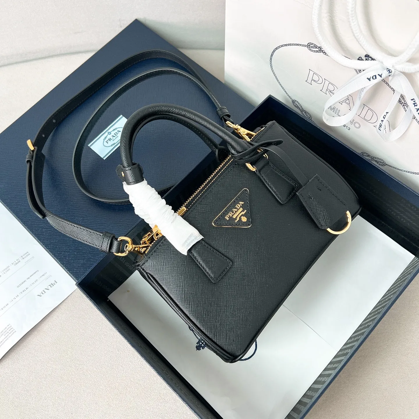 💰1700 ✨New product launch✨P classic Galleria Saffiano leather handbag - "Killer Bag" 2025 new product Mini No. 1BA916 People who know fashion love killer bags. The bag should look like a killer bag. Carefully crafted with Saffiano cross pattern imported from Italy. Minimalist and capable bag shape with triangular metal lettering logo. Double zipper design. The middle main bag has a large capacity. Double handles and detachable shoulder straps make it It can be carried by hand or carried across the shoulder. It can be opened and closed with side snap buttons. The bag body changes to add elegance and elegance. It is small and exquisite, adding a playful and fashionable feel. Size 21*12.5*8.5 Black