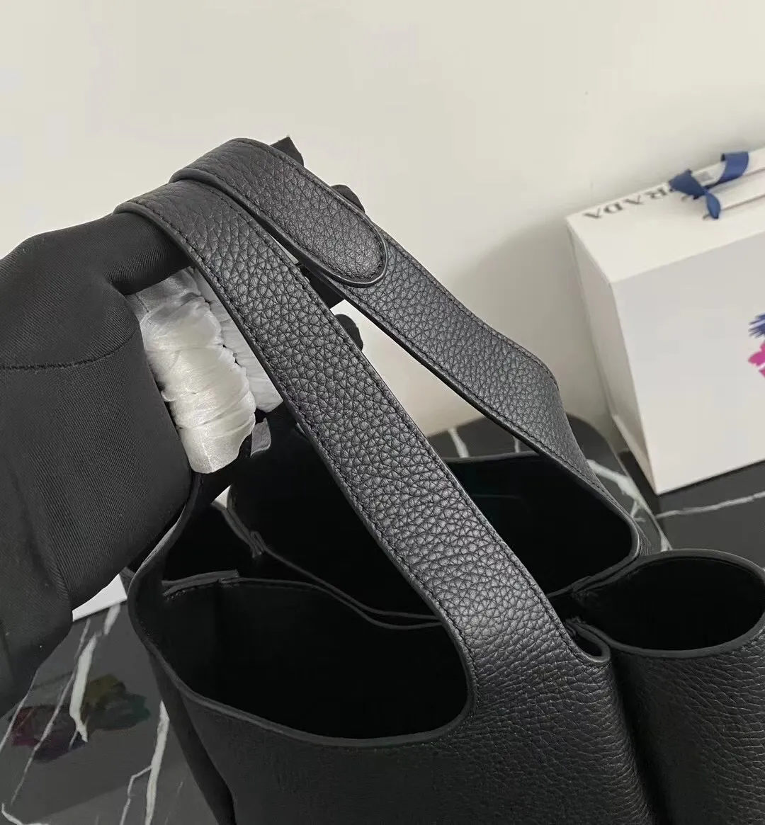 P1300¥ [Top original order] (New version) 1BG335 vegetable basket bucket bag has arrived🎉Soft and delicate calfskin vegetable basket tote armpit bag, full leather inside and outside with a single handle decorated with silver metal logo, the overall bag body is very Soft and lightweight, the style is elegant and outstanding. The two side pockets not only meet the needs of exquisite storage, but also add elegant charm. It can be carried as an armpit bag, a must-have for goddesses. OEM code 165, size 25*21.5*14cm!