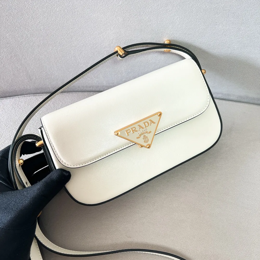 💰1440✨New product launch✨2023 new series shoulder bag 1BD339 is made of exquisite calfskin and is equipped with the iconic triangular logo decorative lock. The shoulder strap is adjustable and can be carried under the armpit or on one shoulder. The overall style of the bag is simple and the lines are elegant. Fashion and retro style are combined. The inner compartment capacity is also great. It is a new fashion trendsetter that combines retro fashion and practicality😘 Size 20.5*10.5*4 white