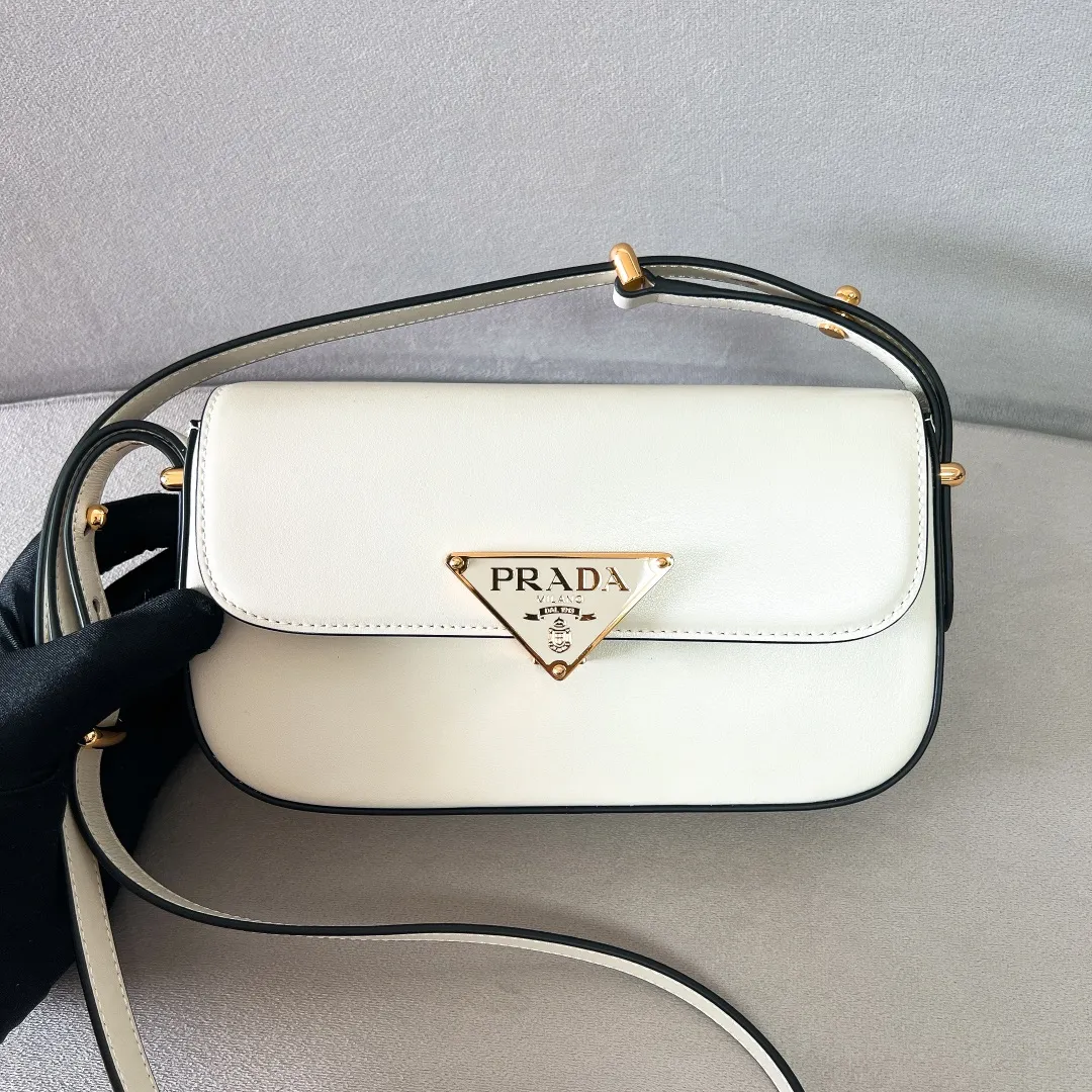 💰1440✨New product launch✨2023 new series shoulder bag 1BD339 is made of exquisite calfskin and is equipped with the iconic triangular logo decorative lock. The shoulder strap is adjustable and can be carried under the armpit or on one shoulder. The overall style of the bag is simple and the lines are elegant. Fashion and retro style are combined. The inner compartment capacity is also great. It is a new fashion trendsetter that combines retro fashion and practicality😘 Size 20.5*10.5*4 white