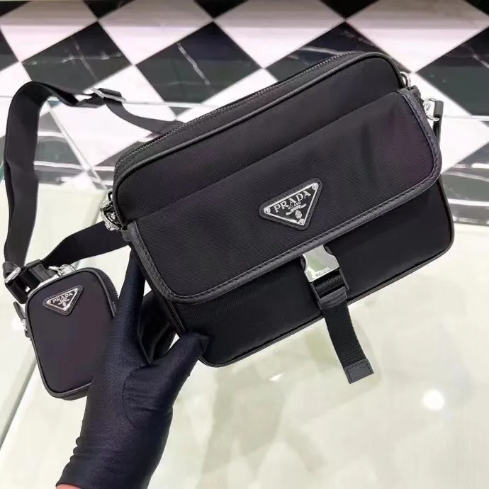 p600¥🎉New messenger bag🎉2VH133B🎉🎉This crossbody bag is made of imported nylon fabric, top-grade hardware🎉🎉Detachable and adjustable nylon strap and leather shoulder strap, with detachable pouch, flip cover coated with enamel gold It has a triangular logo zipper closure, external pockets, a flap and side opening buttons, and a recycled nylon lining. It is lightweight and practical, and it is a popular style that will never go out of style🎉🎉Worth owning🎉🎉Length 22x Height 16x Bottom 5cm