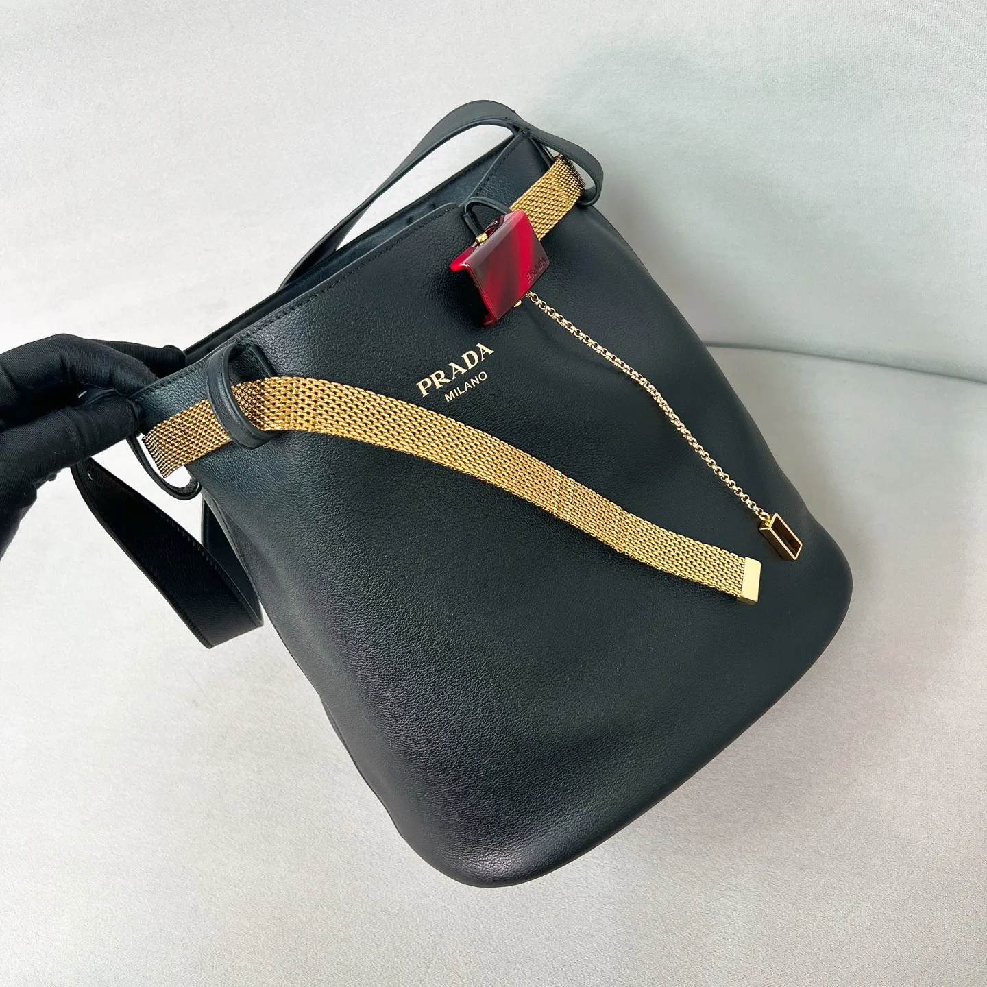 💰1700✨New product launch✨2025 spring and summer new product Buckle bucket bag 1BE085 inherits the classic bucket bag shape. The newly designed leather belt has a unique style that makes the bag infinitely dynamic. It is made of chic and noble calfskin. The bag is decorated with metallic mesh design. It is equipped with tortoise shell panel buckle. Elegant and simple bag body design is decorated with unique hardware decoration, showing a refined and elegant aesthetic style. Equipped with an adjustable hand strap, perfect details comparable to brick cabinets, super awesome 5🌟 size: 29*26.5*18cm black