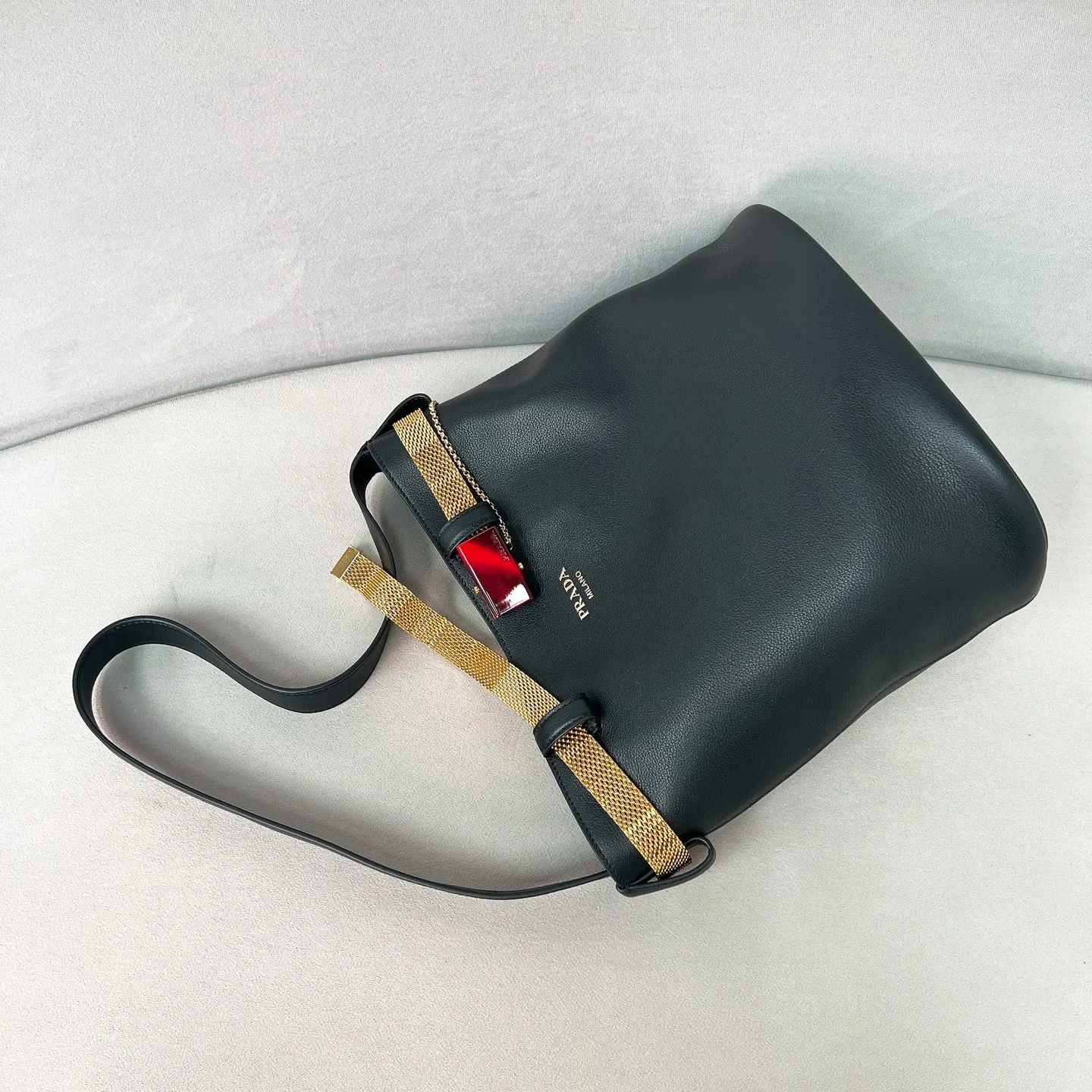 💰1700✨New product launch✨2025 spring and summer new product Buckle bucket bag 1BE085 inherits the classic bucket bag shape. The newly designed leather belt has a unique style that makes the bag infinitely dynamic. It is made of chic and noble calfskin. The bag is decorated with metallic mesh design. It is equipped with tortoise shell panel buckle. Elegant and simple bag body design is decorated with unique hardware decoration, showing a refined and elegant aesthetic style. Equipped with an adjustable hand strap, perfect details comparable to brick cabinets, super awesome 5🌟 size: 29*26.5*18cm black