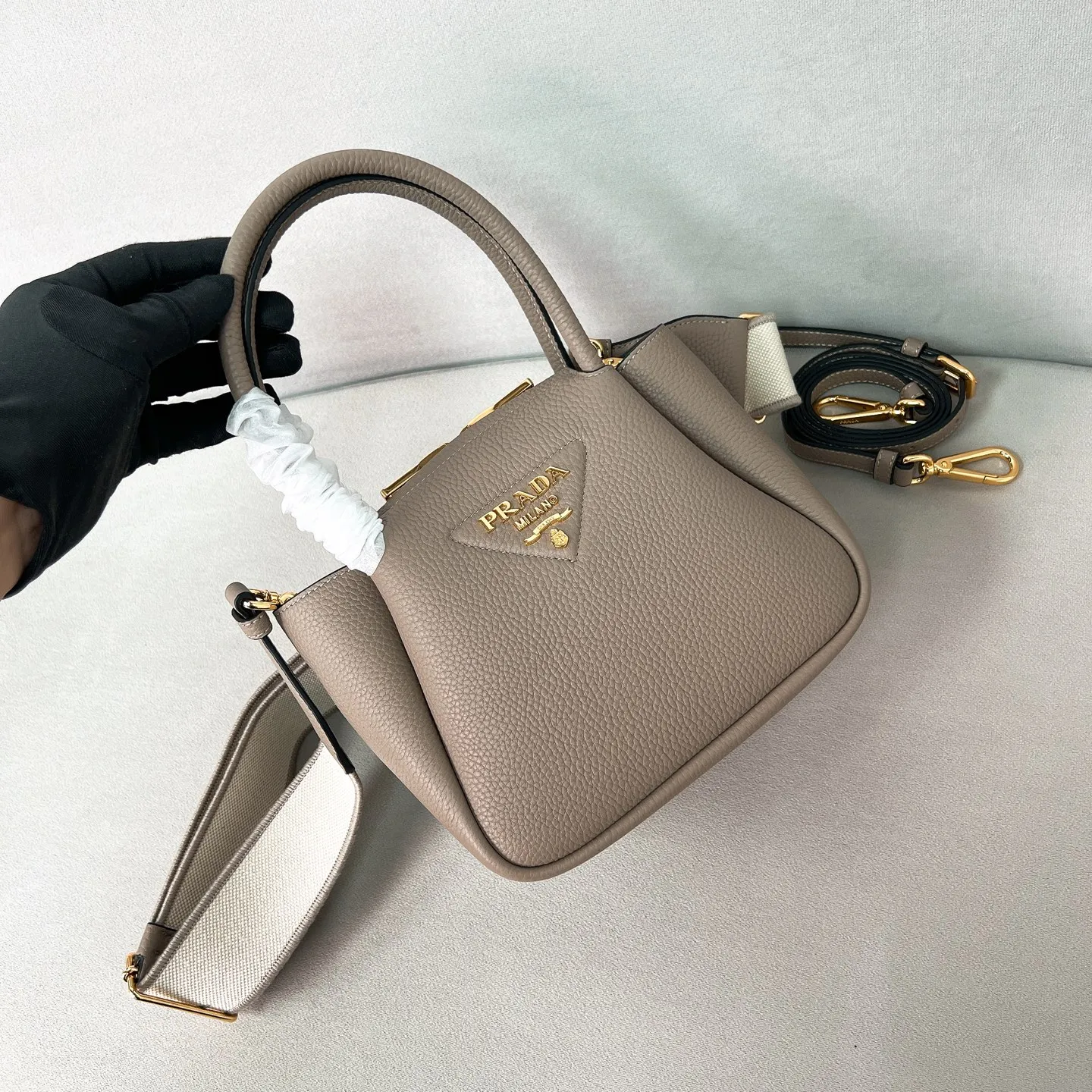 💰1760 ✨New product debut✨2025 new mini pebbled handbag/shoulder bag 1BA362 is made of soft textured pebbled calfskin. The bag has a rounded and soft silhouette. It is equipped with double handles and is decorated with a gold metal logo. Multifunctional detachable embroidered shoulder strap and leather shoulder strap. Elegant and outstanding style. Can be carried by hand, shoulder or crossbody. A handbag that perfectly blends classic heritage with contemporary trends. A must-have for fairies. Size 19.5*18*9cm