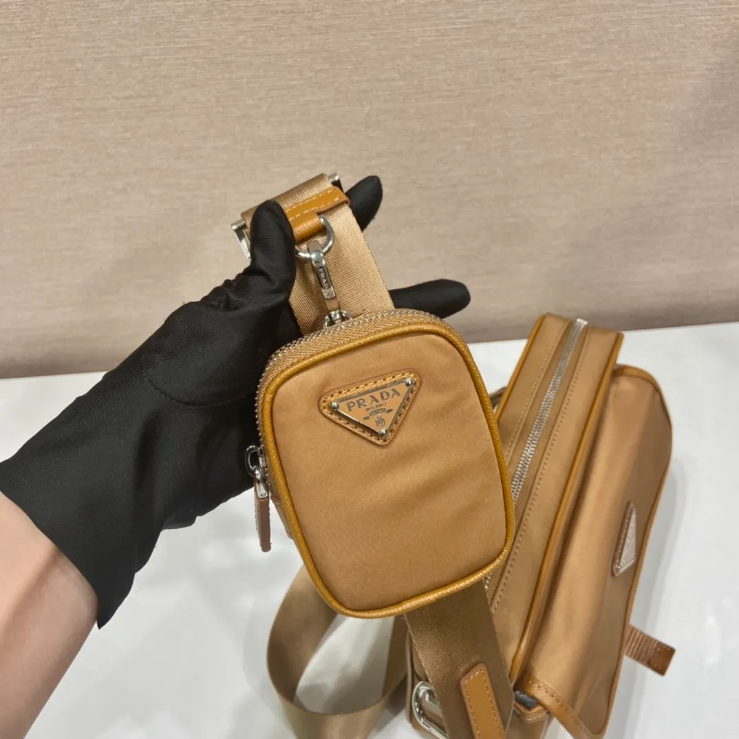 💰1020🎉New messenger bag🎉2VH133B🎉🎉New color This crossbody bag is made of imported nylon fabric, top-grade hardware🎉🎉Detachable adjustable nylon strap and leather shoulder strap, with detachable pouch, flip-top coated with enamel metal triangle logo Zipper closure, external pockets, with flaps and side buckles, recycled nylon lining, lightweight and practical, and a timeless and popular style🎉🎉worth owning🎉🎉 Length 22x Height 16x Bottom 5cm