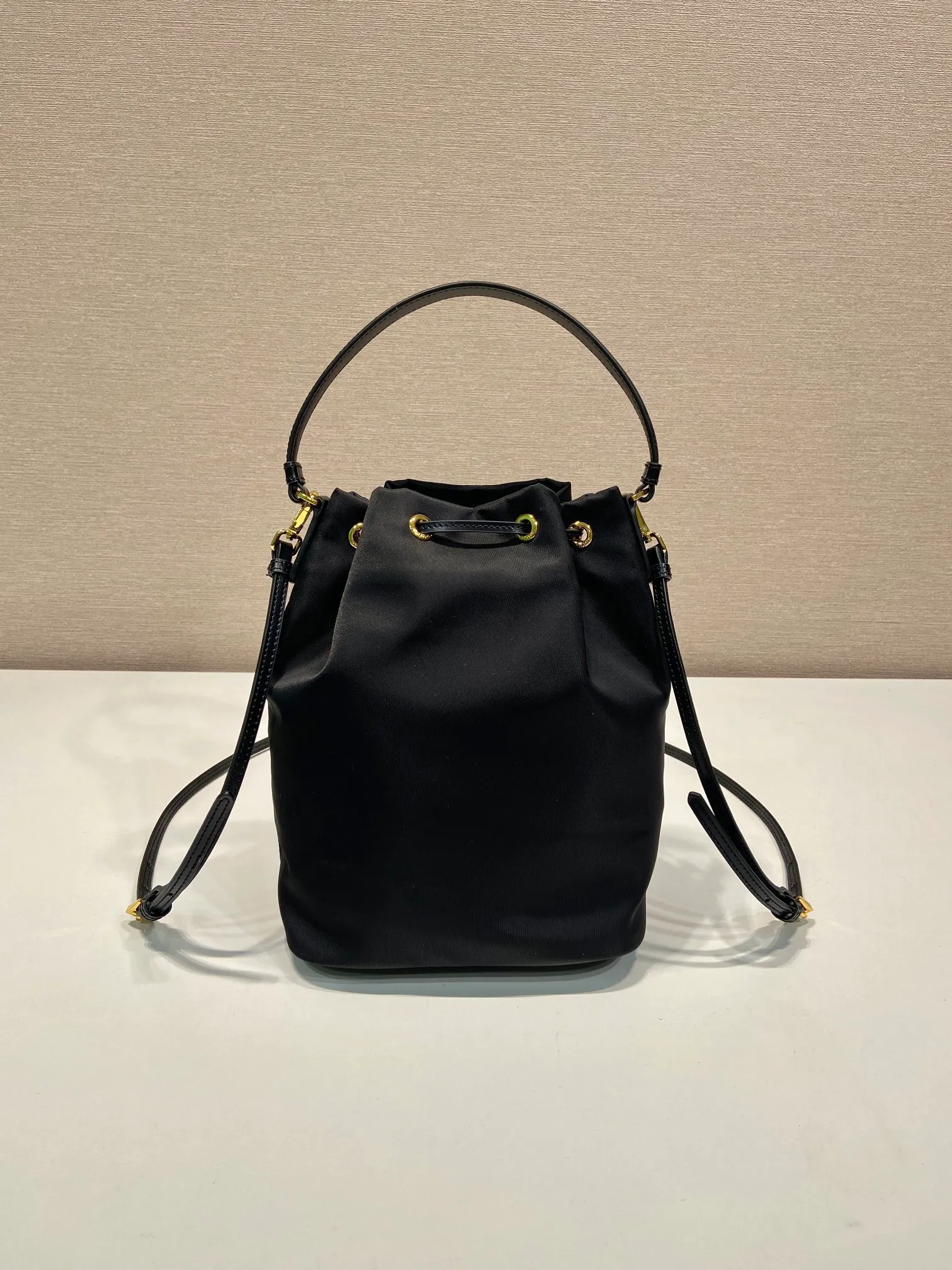 💰920🎉New bucket🎉1BH038 glossy/nylon fabric🎉🎉This casual and versatile bucket bag presents soft and smooth lines, highlighting modern style. Equipped with detachable handles and shoulder straps, it can be carried by hand or worn cross-body. It combines practical and innovative re-Nylon fabric (Re-Nylon), exquisite glossy leather details, and metal hardware. Featuring exterior zip pocket with enameled metal triangle logo. Another popular style that will never go out of style🎉🎉Babies; hurry up and get it🎉🎉 Length 17.5x Height 22.5x12cm