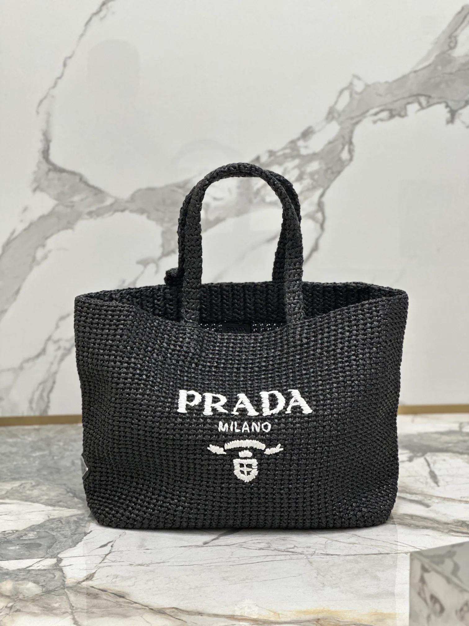 💰1900🌟Woven Tote Bag (Large Size) This tote bag is made of lightweight natural raffia fiber that is full of summer style. The soft deconstructed design gives the bag a unique modern charm. The iconic Prada lettering logo embroidery on the front subtly embellishes the silhouette. The striped pattern adds a contrasting element. So summery! Very versatile for everyday use. Size: length 40cm×height 34×width 15cm Style number: 1BG392