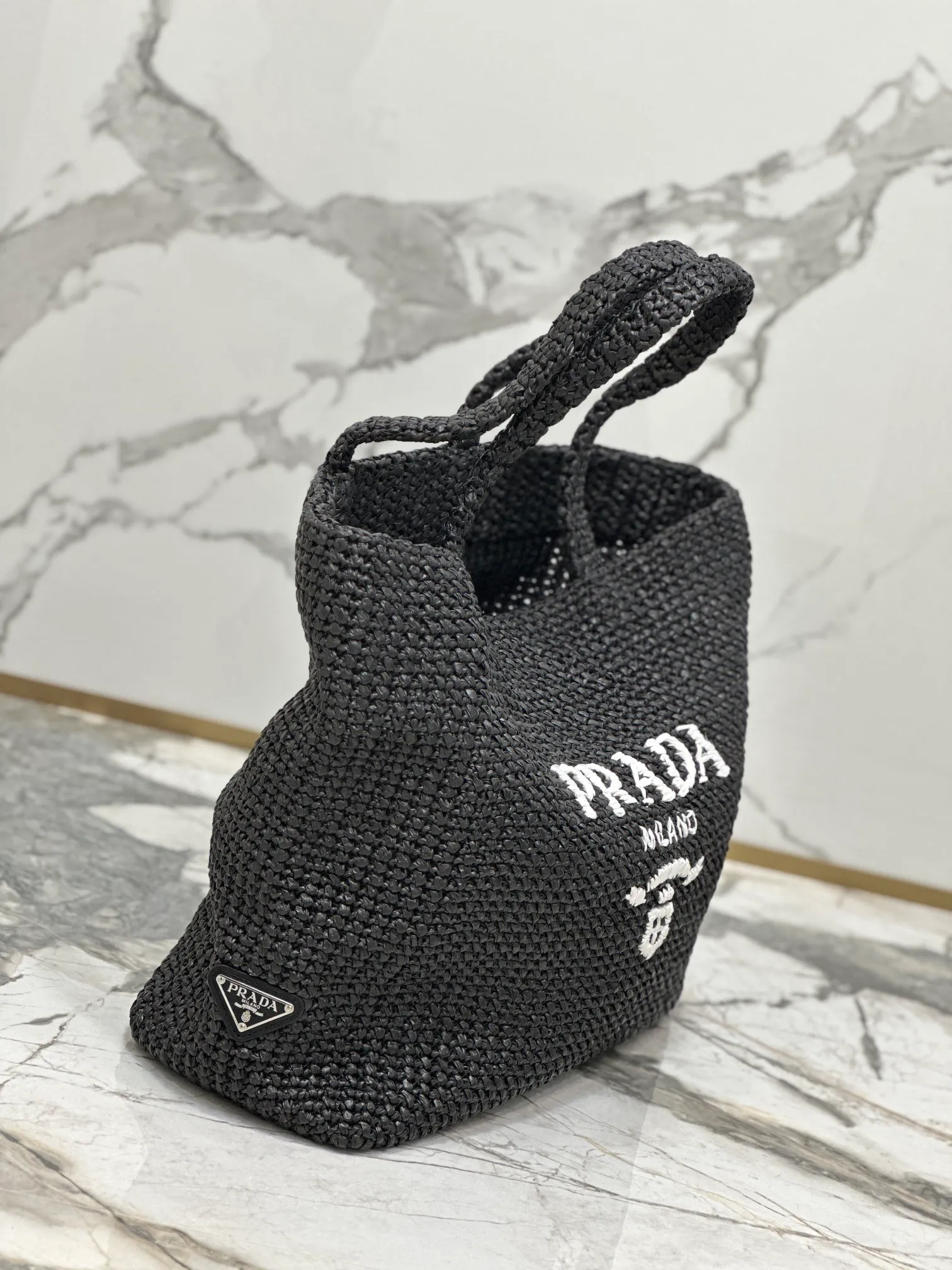 💰1900🌟Woven Tote Bag (Large Size) This tote bag is made of lightweight natural raffia fiber that is full of summer style. The soft deconstructed design gives the bag a unique modern charm. The iconic Prada lettering logo embroidery on the front subtly embellishes the silhouette. The striped pattern adds a contrasting element. So summery! Very versatile for everyday use. Size: length 40cm×height 34×width 15cm Style number: 1BG392