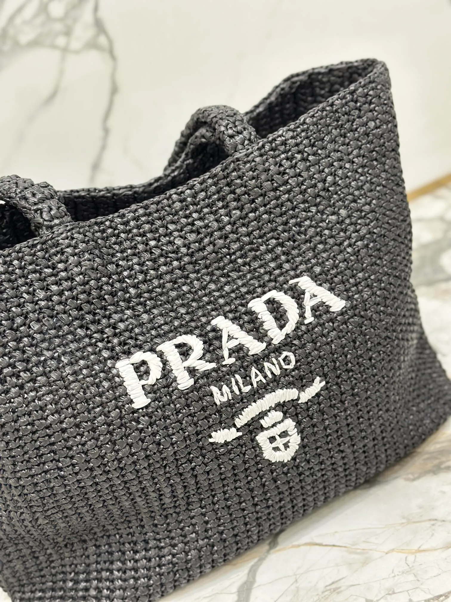 💰1900🌟Woven Tote Bag (Large Size) This tote bag is made of lightweight natural raffia fiber that is full of summer style. The soft deconstructed design gives the bag a unique modern charm. The iconic Prada lettering logo embroidery on the front subtly embellishes the silhouette. The striped pattern adds a contrasting element. So summery! Very versatile for everyday use. Size: length 40cm×height 34×width 15cm Style number: 1BG392