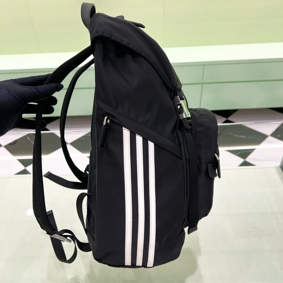 💰1420✨New product launch✨New product Prad@✖️Adid@s co-branded series backpack 2VZ135 Imported parachute nylon fabric Triangle logo on the front Classic three-stripe cowhide accessories on the side Clover➕Recycled nylon logo on the side Adjustable nylon shoulder straps with flip-up buckle and internal drawstring closure Perfect details on the back padding 😘With OEM code A must-have for fashionable casual fashionistas The latest trendy must-have series for men size: 17-27-45cm