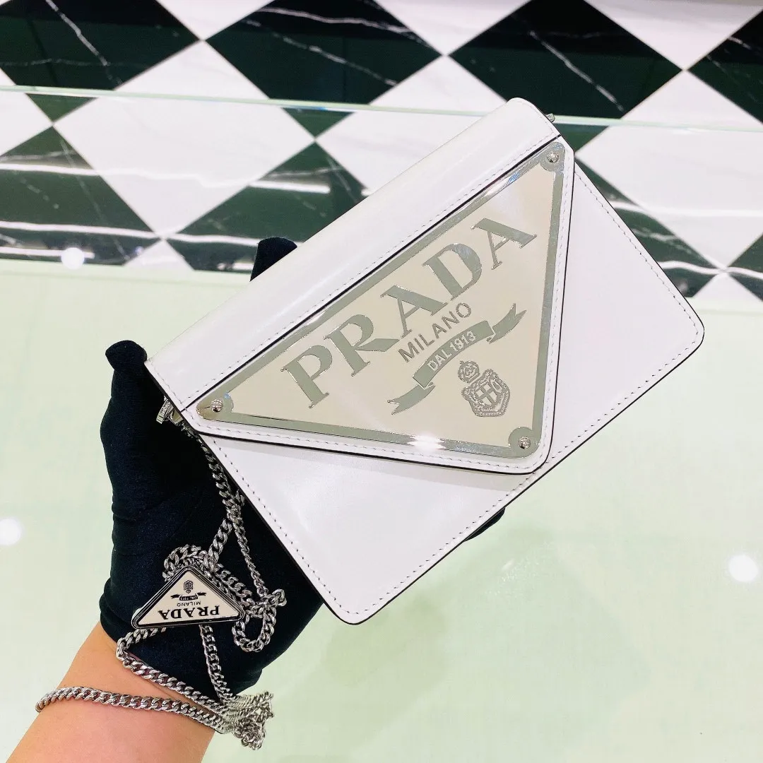 💰1320✨ New product debut✨🌟New inverted triangle decorated glossy cowhide flip shoulder bag 1BH189 Novel and interesting inverted triangle metal chain with fashionable glossy cowhide. The simple and elegant outline design and flip opening and closing give it a simple and fashionable style. It is simply great👏... The new favorite of fashion trendsetters. The perfect details are comparable to those of brick cabinets Super 5🌟 Size:17*9.5*3.5cm white