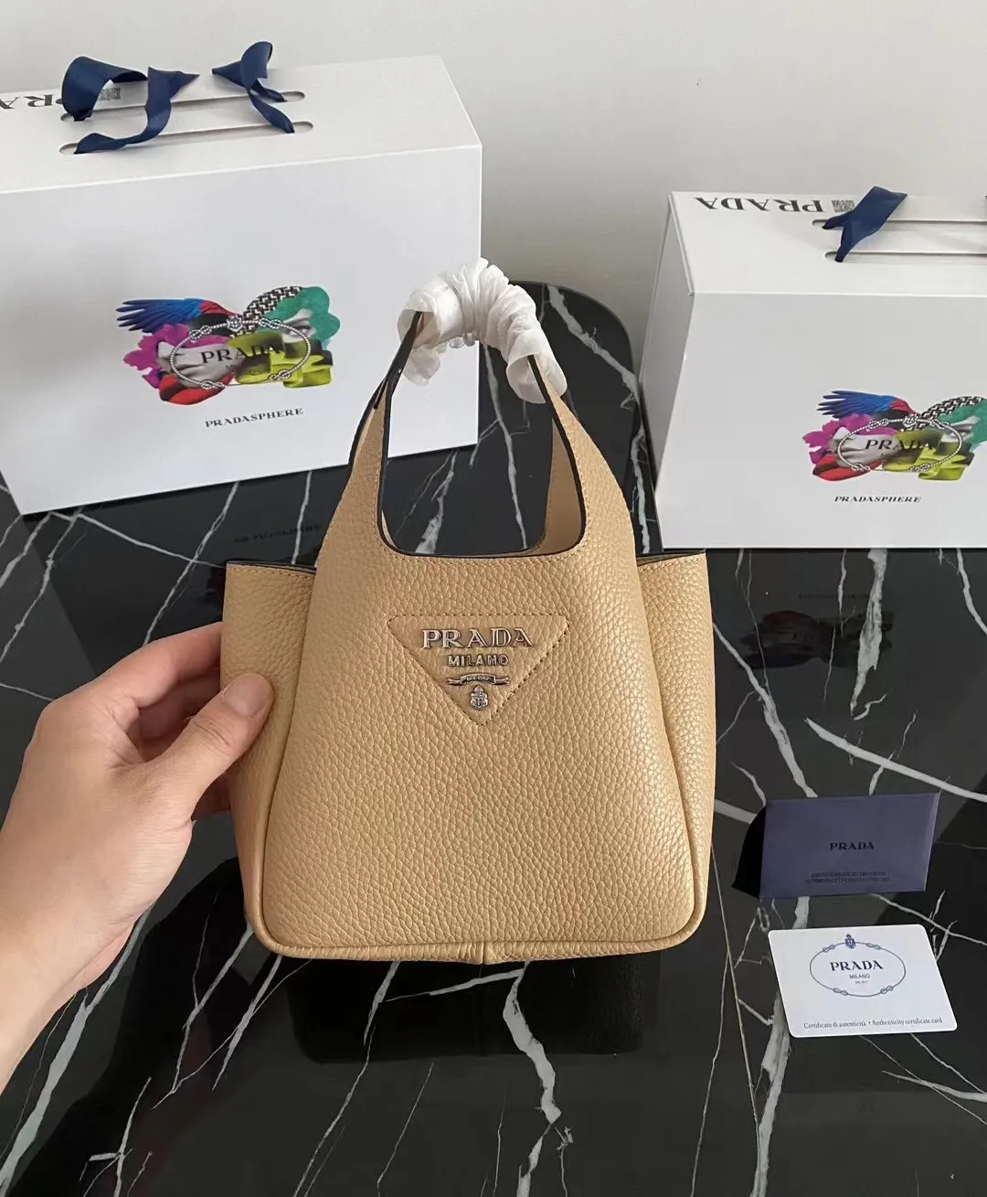 P1100¥ [Top original order] The latest 2022 vegetable basket tote bag mini model 1BA349 has arrived🎉🎉Soft and delicate pebbled calfskin tote bag, full leather inside and outside, equipped with double handles, decorated with silver metal logo, the overall body of the bag is very soft Lightweight, elegant and outstanding. The two side pockets not only meet the needs of exquisite storage but also add an elegant charm. It can be carried as a handbag or an armpit bag. It is a must-have handbag for fairies that perfectly combines classic heritage with the trend of the times. Size: 18︸15.5︸10CM!
