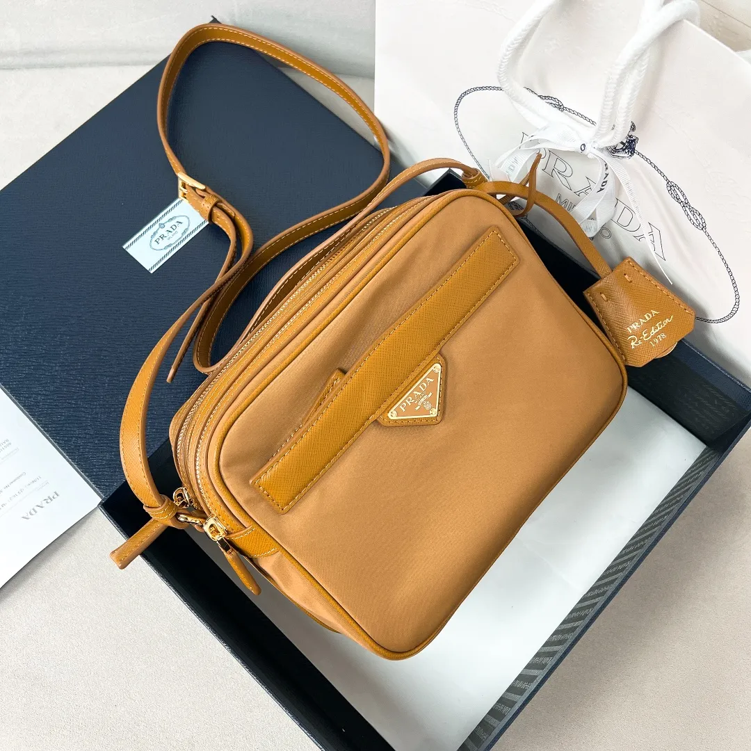 💰1160✨New product debut✨2024Summer new product Re-Edition1978 mini shoulder bag 1BH218 New design mini shoulder bag Made of imported nylon fabric➕Saffiano cowhide trim Elegant and simple bag design Classic logo gold triangle logo on the front Equipped with full leather adjustable long shoulder strap Double zipper closure Equipped with two space compartments➕zipper patch pocket and mobile phone patch pocket Meets exquisite storage needs, perfect details comparable to brick cabinets Super 5🌟 Size: 21*17*8cm