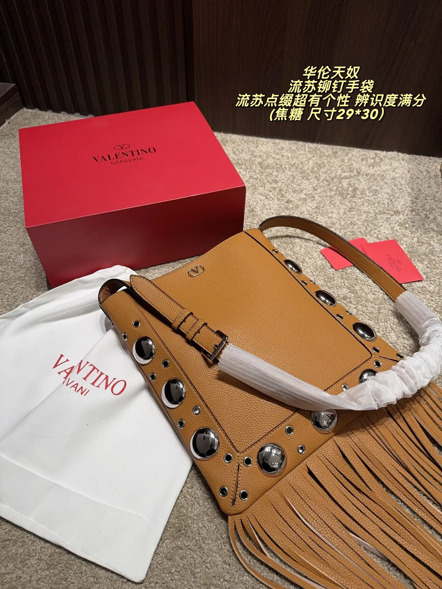 P480 comes with box⚠️Size 29*30 Valentino tassel rivet handbag. The tassel embellishment is super personalized! The V-shaped logo on the front is super classic and highly recognizable. The shoulder strap is adjustable, so it can be carried by hand or carried on the shoulder. It has a large capacity and can hold daily small items for commuting and traveling. The rivets and tassel design make the bag more layered, and it looks great with simple or retro styles. It is practical and fashionable, and can easily enhance the quality of your outfit!