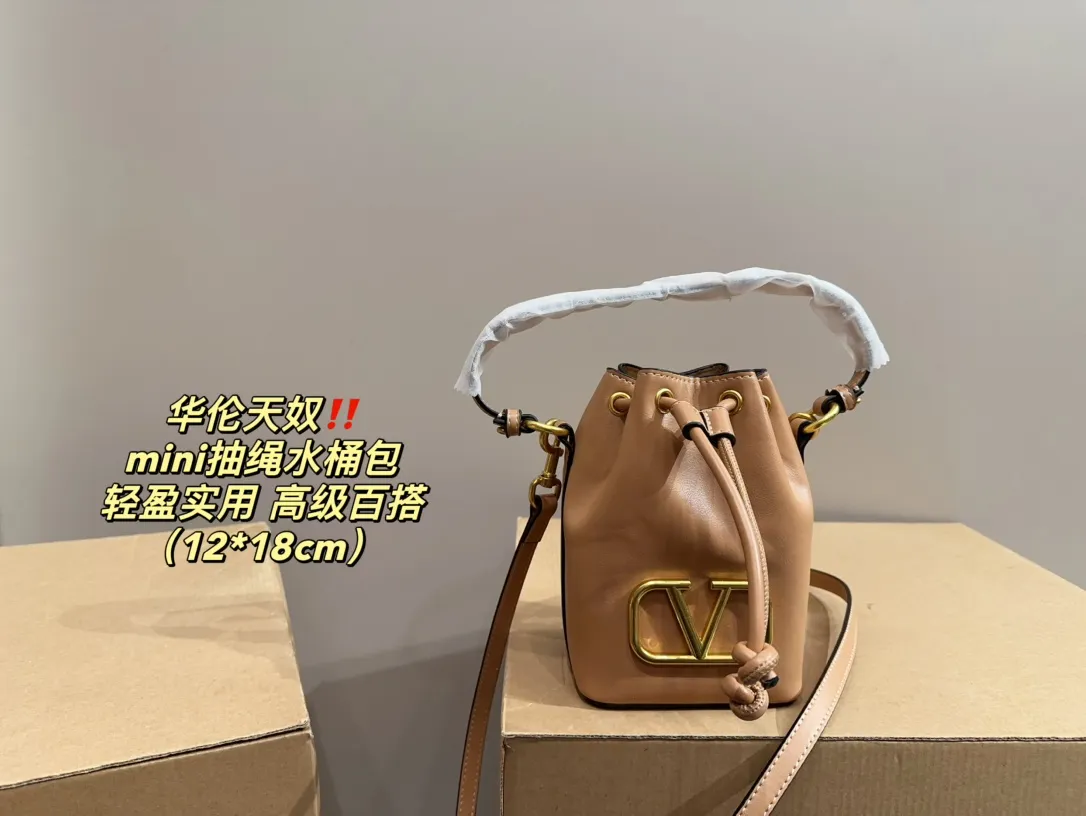 P310 comes with folding box ⚠️Size 12.18 Valentino mini drawstring bucket bag. The texture is very soft. The chain and logo are all gold. Sisters, don’t worry. This bag is very light, and I think it is very practical. It is very easy to match and the capacity is quite large. Basically, when we girls go out, we can put daily things in it. The black color with gold logo and chain looks really high-end and very attractive.