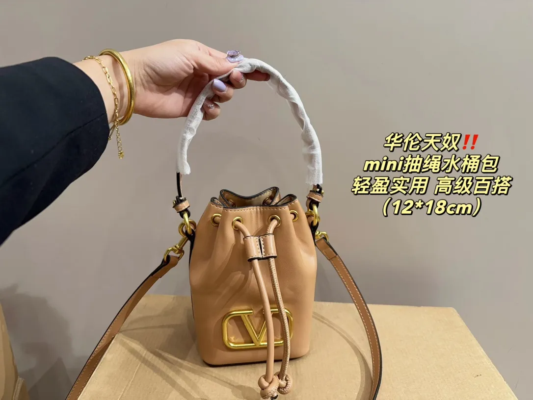 P310 comes with folding box ⚠️Size 12.18 Valentino mini drawstring bucket bag. The texture is very soft. The chain and logo are all gold. Sisters, don’t worry. This bag is very light, and I think it is very practical. It is very easy to match and the capacity is quite large. Basically, when we girls go out, we can put daily things in it. The black color with gold logo and chain looks really high-end and very attractive.