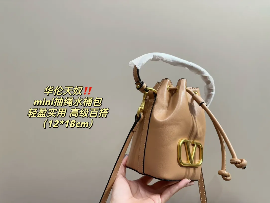 P310 comes with folding box ⚠️Size 12.18 Valentino mini drawstring bucket bag. The texture is very soft. The chain and logo are all gold. Sisters, don’t worry. This bag is very light, and I think it is very practical. It is very easy to match and the capacity is quite large. Basically, when we girls go out, we can put daily things in it. The black color with gold logo and chain looks really high-end and very attractive.