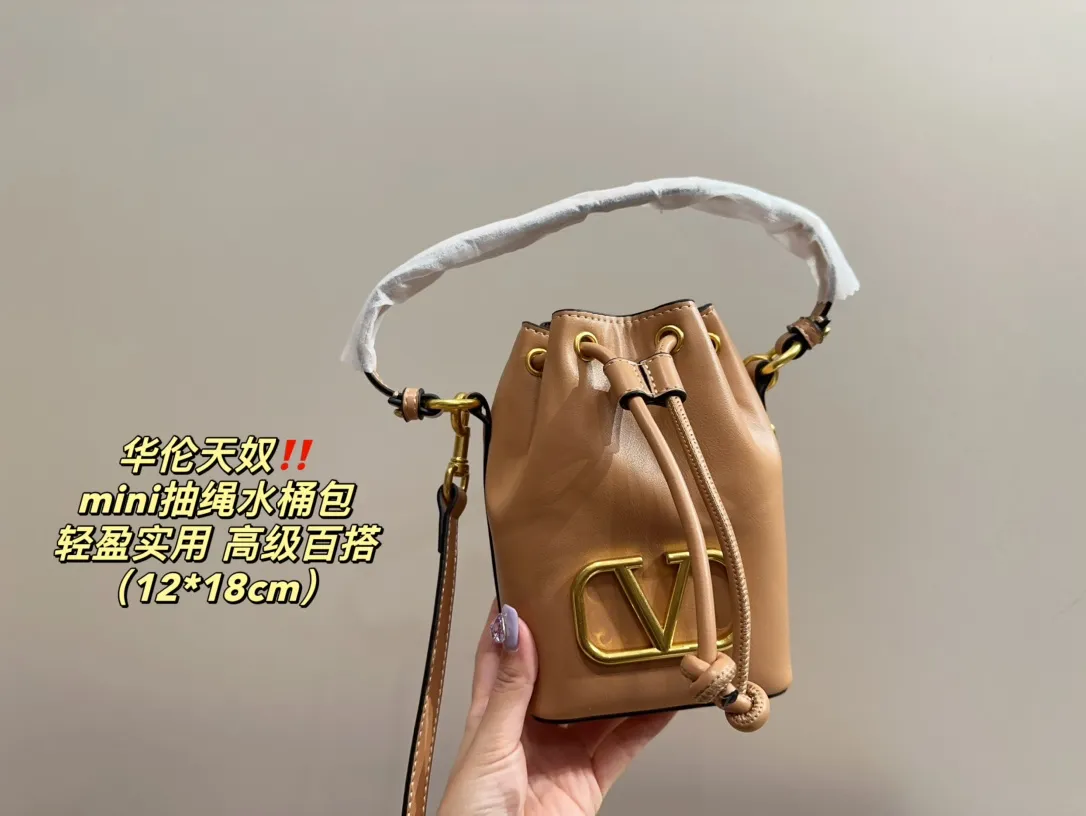 P310 comes with folding box ⚠️Size 12.18 Valentino mini drawstring bucket bag. The texture is very soft. The chain and logo are all gold. Sisters, don’t worry. This bag is very light, and I think it is very practical. It is very easy to match and the capacity is quite large. Basically, when we girls go out, we can put daily things in it. The black color with gold logo and chain looks really high-end and very attractive.
