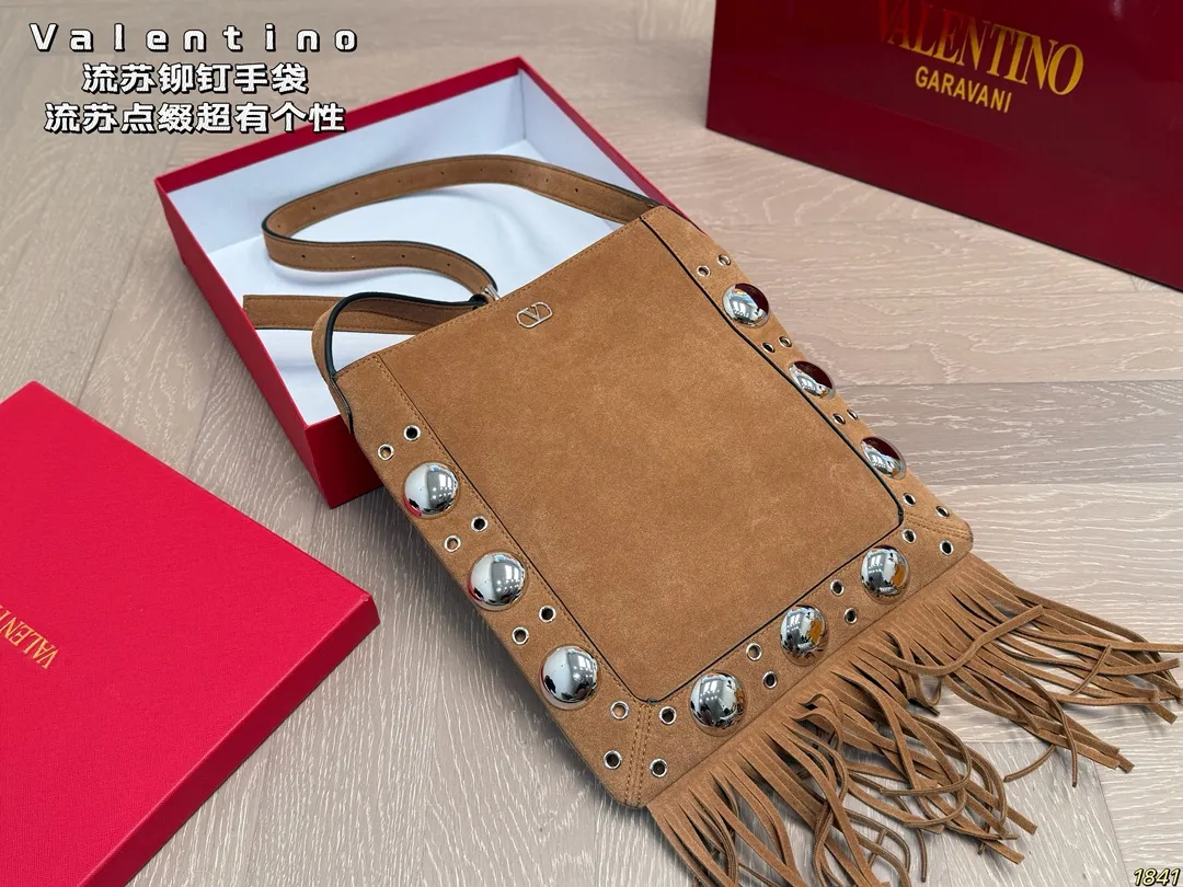 ¥330 with box Valentino tassel rivet handbag The tassel embellishment is super personalized! The V-shaped logo on the front is super classic and highly recognizable. The shoulder strap is adjustable, so it can be carried by hand or carried on the shoulder. It has a large capacity and can hold daily small items for commuting and traveling. The rivets and tassel design make the bag more layered, and it looks great with simple or retro styles. It is practical and fashionable, and can easily enhance the quality of your outfit! Size 29*30
