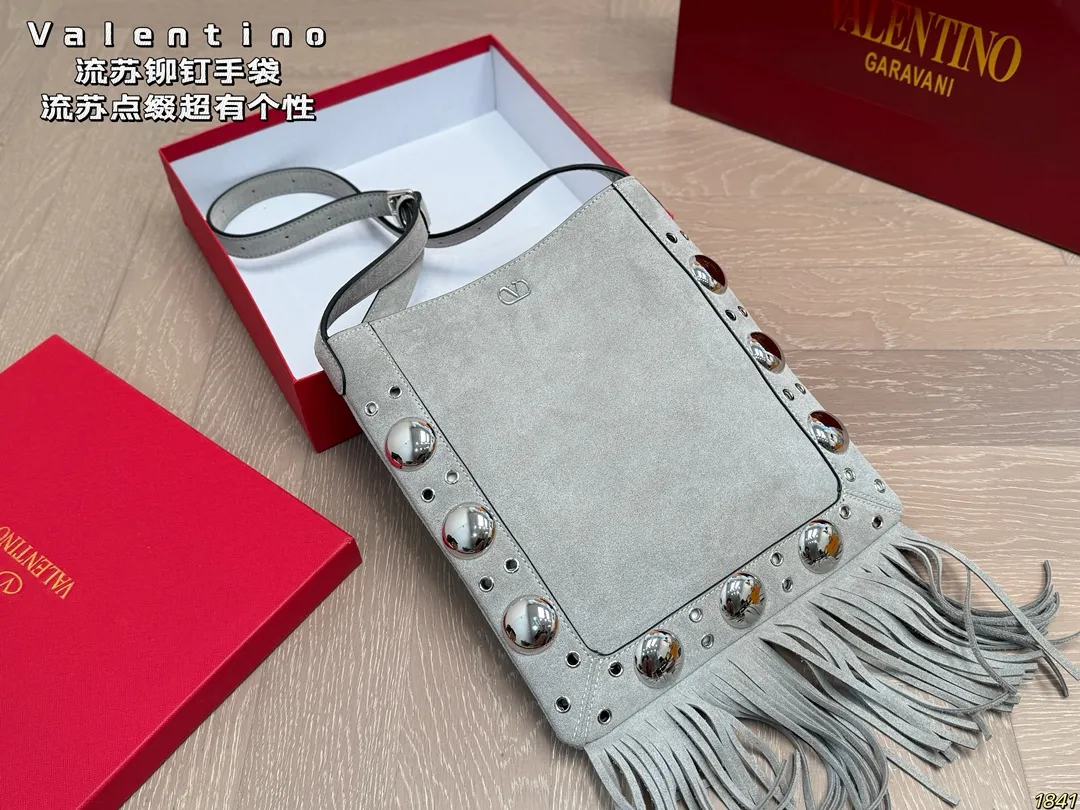 4️⃣Color ¥330 with box Valentino tassel rivet handbag The tassel embellishment is super personalized! The V-shaped logo on the front is super classic and highly recognizable. The shoulder strap is adjustable, so it can be carried by hand or carried on the shoulder. It has a large capacity and can hold daily small items for commuting and traveling. The rivets and tassel design make the bag more layered, and it looks great with simple or retro styles. It is practical and fashionable, and can easily enhance the quality of your outfit! Size 29*30