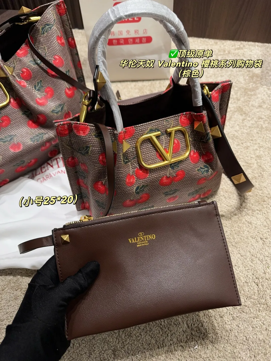 ✅Top original order Large p440 with box⚠️Size 37.23 Small p410 with box⚠️Size 25.20 Valentino Cherry Series Shopping Bag The bright cherries on the top are matched with dark green branches and leaves, and the retro pastoral style blows in, as if you have traveled to a romantic pastoral in one second🍃 The brown leather edging is extremely exquisite, and the iconic metal "V" buckle is even more eye-catching. The texture is instantly full and the sense of luxury is overwhelming✨This bag is super versatile and can be worn with a small skirt to show off its sweet temperament; paired with casual wear, it can show off its cool and handsome side, lighting up the overall look in minutes. Carry it on your back when you go out, and you will be a sweet and cool girl that everyone loves