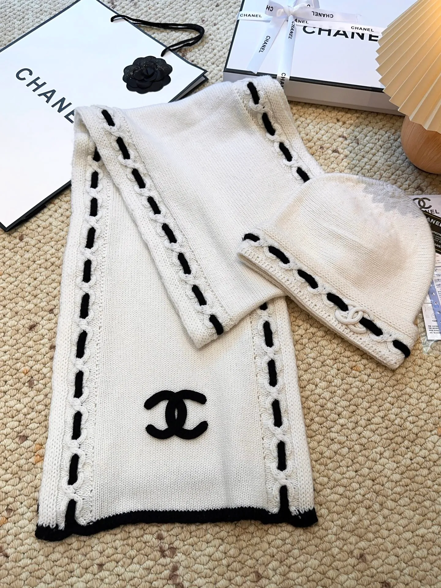 P720 Scarf P350 Hat Single selection available New arrival! Chanel (Chanel) color-blocked striped scarf is made of wool blended material and 7-needle drawing process. The surface of the fabric has three-dimensional textures with a sense of layering and a concave and convex grid texture. After the weaving is completed, the scarf is hand-picked with the logo in black and white classic colors to show the elegance. Wear it casually to create a simple and fashionable feeling and immediately enhance the overall look.